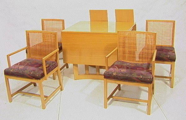 Paul Laszlo Style Dining Table & 4 Chairs. Caned: Paul Laszlo Style Dining Table & 4 Chairs. Caned Back Chairs: 2 Arms, 2 Sides. Drop side table. Two 12" Leaves. Open V Legs. -- Dimensions: H: 29 inches: D: 38 inches: L: 66.5 inches