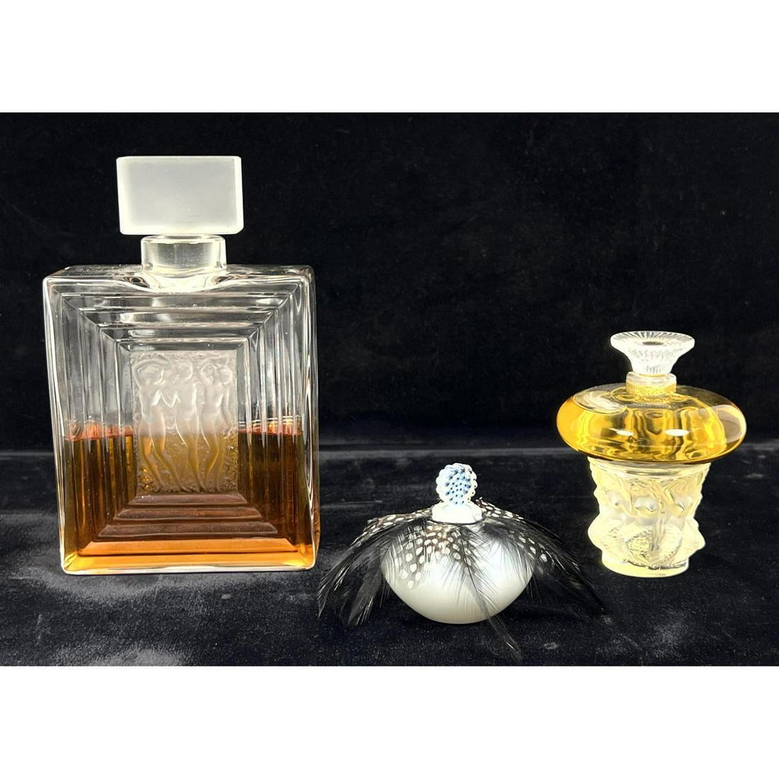 3pc LALIQUE Factice Store Display Perfume Bottles. Mermaid Bottle. Opaque bottle with feathers marke: 3pc LALIQUE Factice Store Display Perfume Bottles. Mermaid Bottle. Opaque bottle with feathers marked Factice. Large Bottle with Frosted three nude graces. All have engraved Lalique, France Mark. Feat