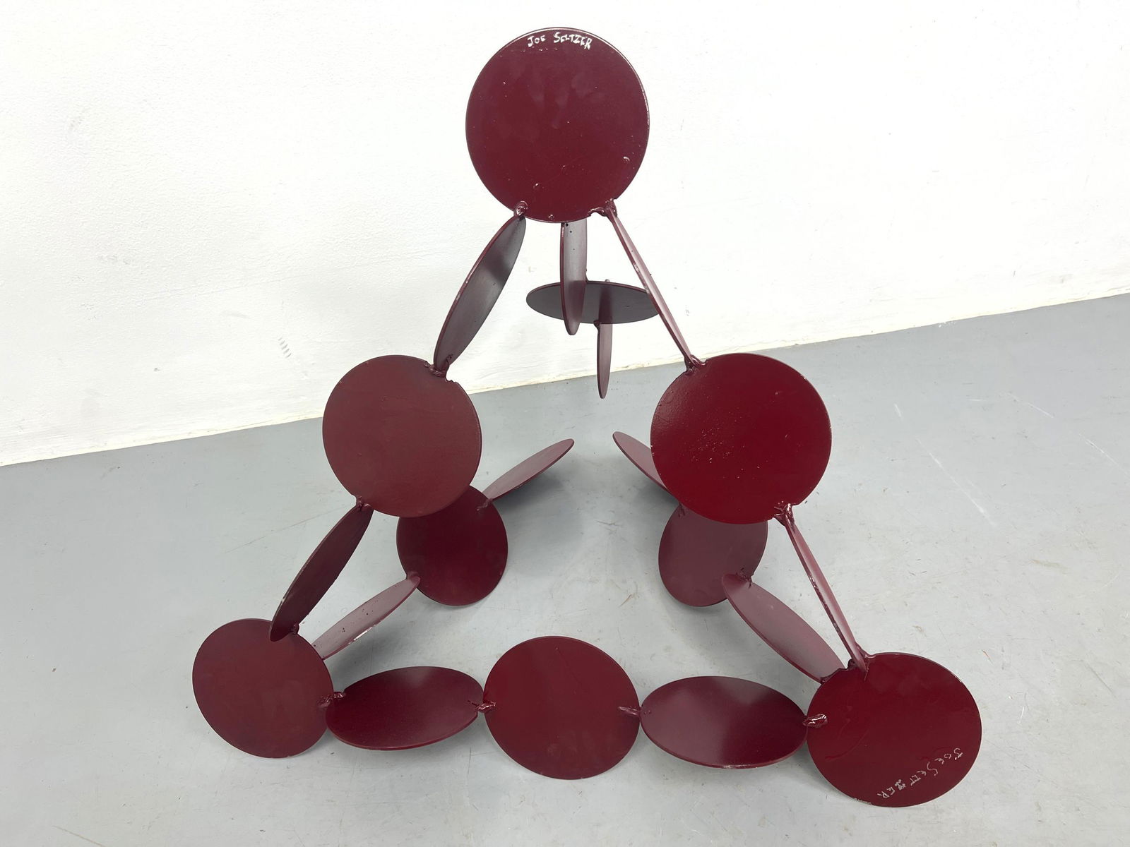 Joe Seltzer, welded found steel objects, titled "Circle Pyramid". Painted Burgundy Red, Signed (1 of 4)