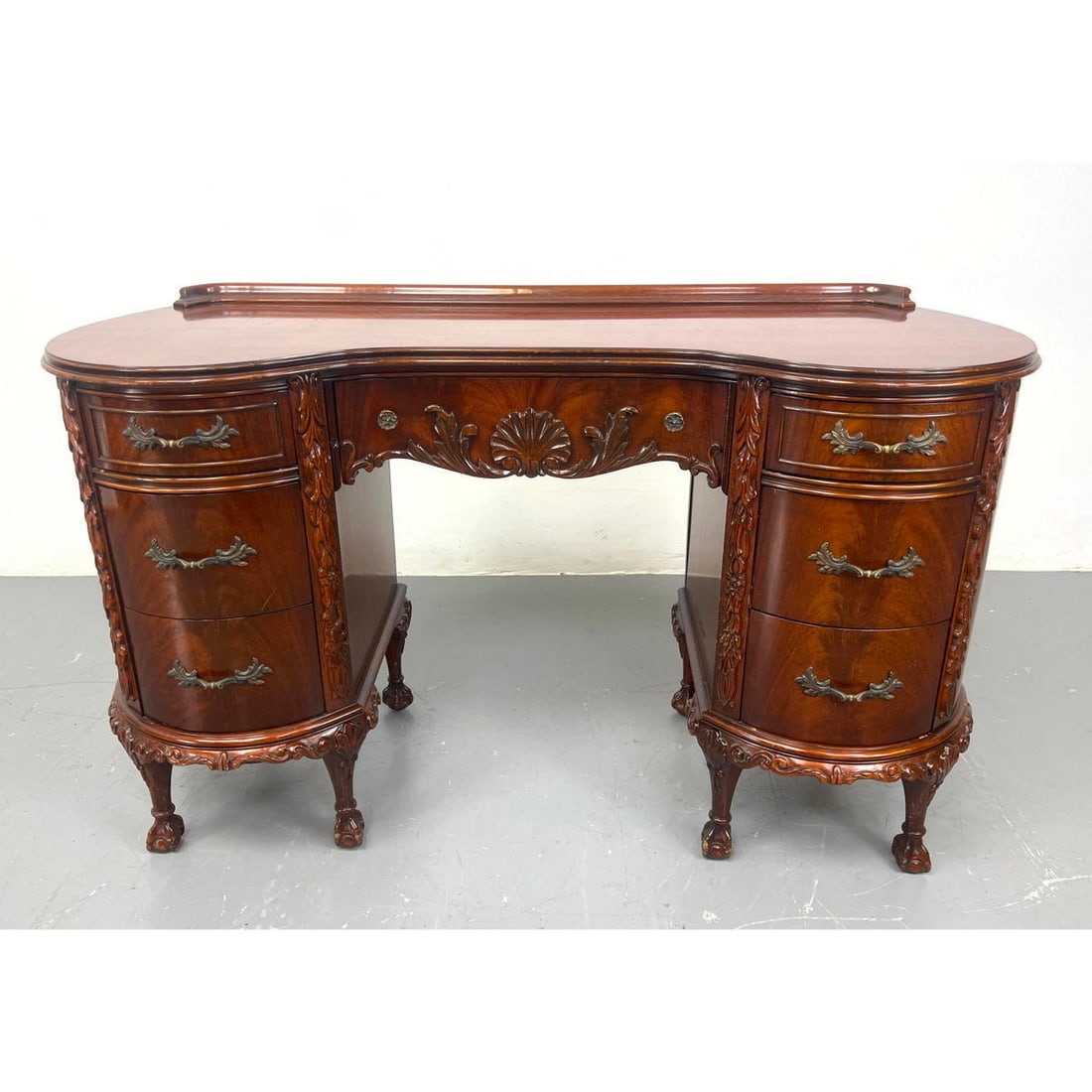 Mahogany vanity with ball and claw feet. Carved trim. Kidney shaped.: Mahogany vanity with ball and claw feet. Carved trim. Kidney shaped. Dimensions: H: 31.5 inches: W: 51 inches: D: 20 inches ---