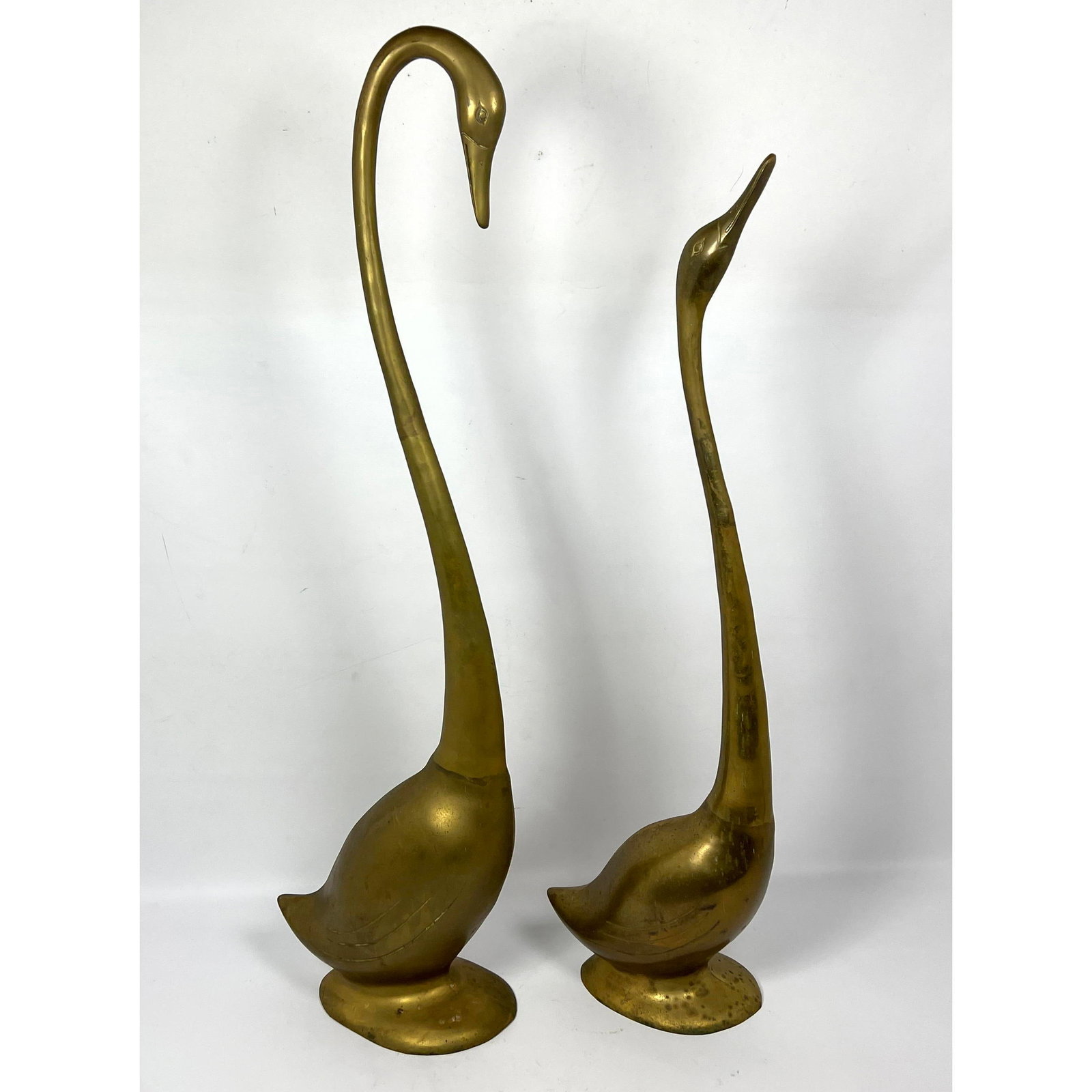 2pc brass Swans floor sculptures.: 2pc brass Swans floor sculptures. Dimensions: Height: 33.5 inches, Width: 5 inches, Depth: 11 inches. - Additional Dimensions: Smaller H: 29.5 inches --- We offer curbside delivery to NYC, Manhattan, 