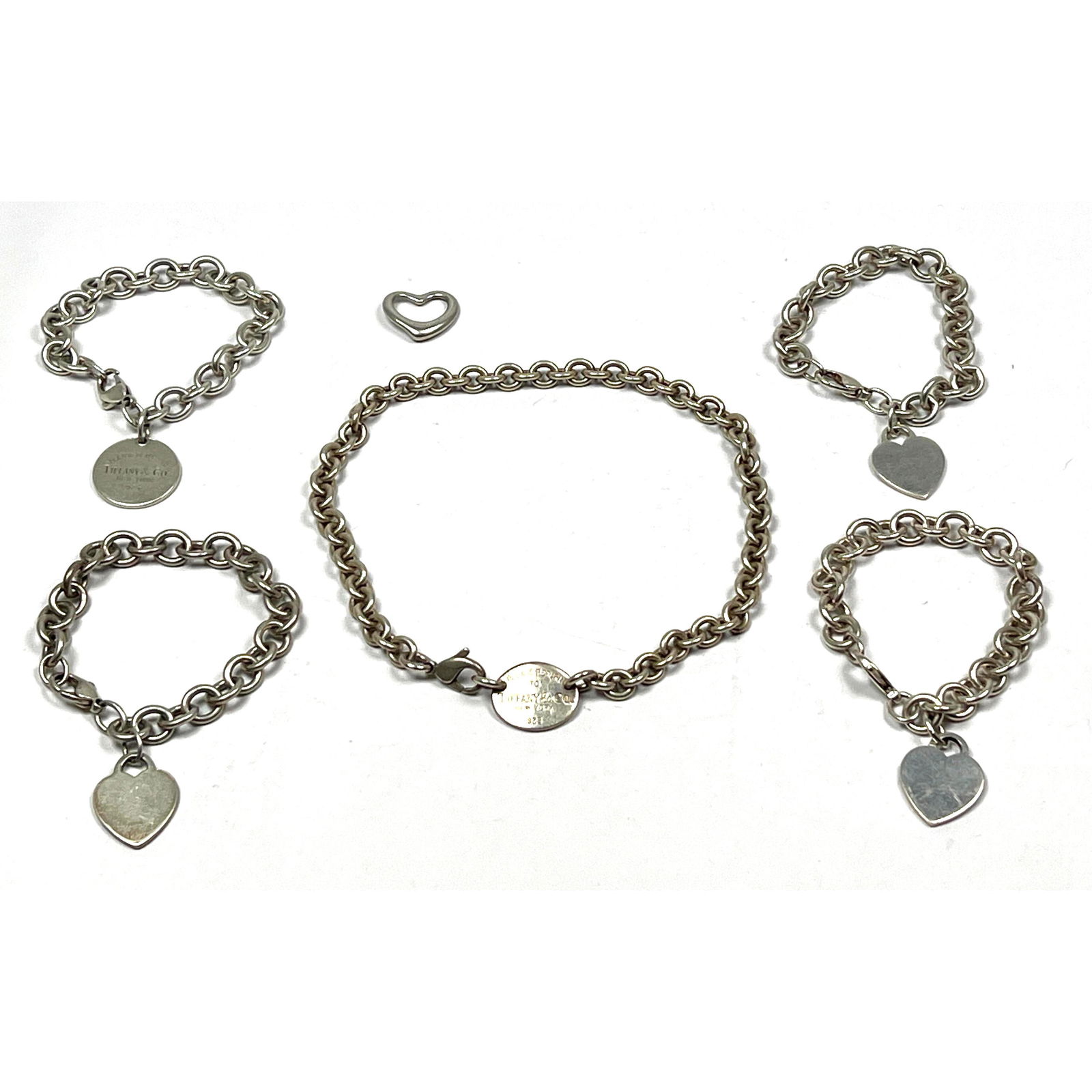6pc TIFFANY and CO Sterling Silver Jewelry Lot. 3pc Heart Charm Open Link Bracelets. One Bracelet wi: 6pc TIFFANY and CO Sterling Silver Jewelry Lot. 3pc Heart Charm Open Link Bracelets. One Bracelet with round Return to Tiffany charm. 15" Link Necklace with Return to Tiffany Link. ELSA PERETTI Open H