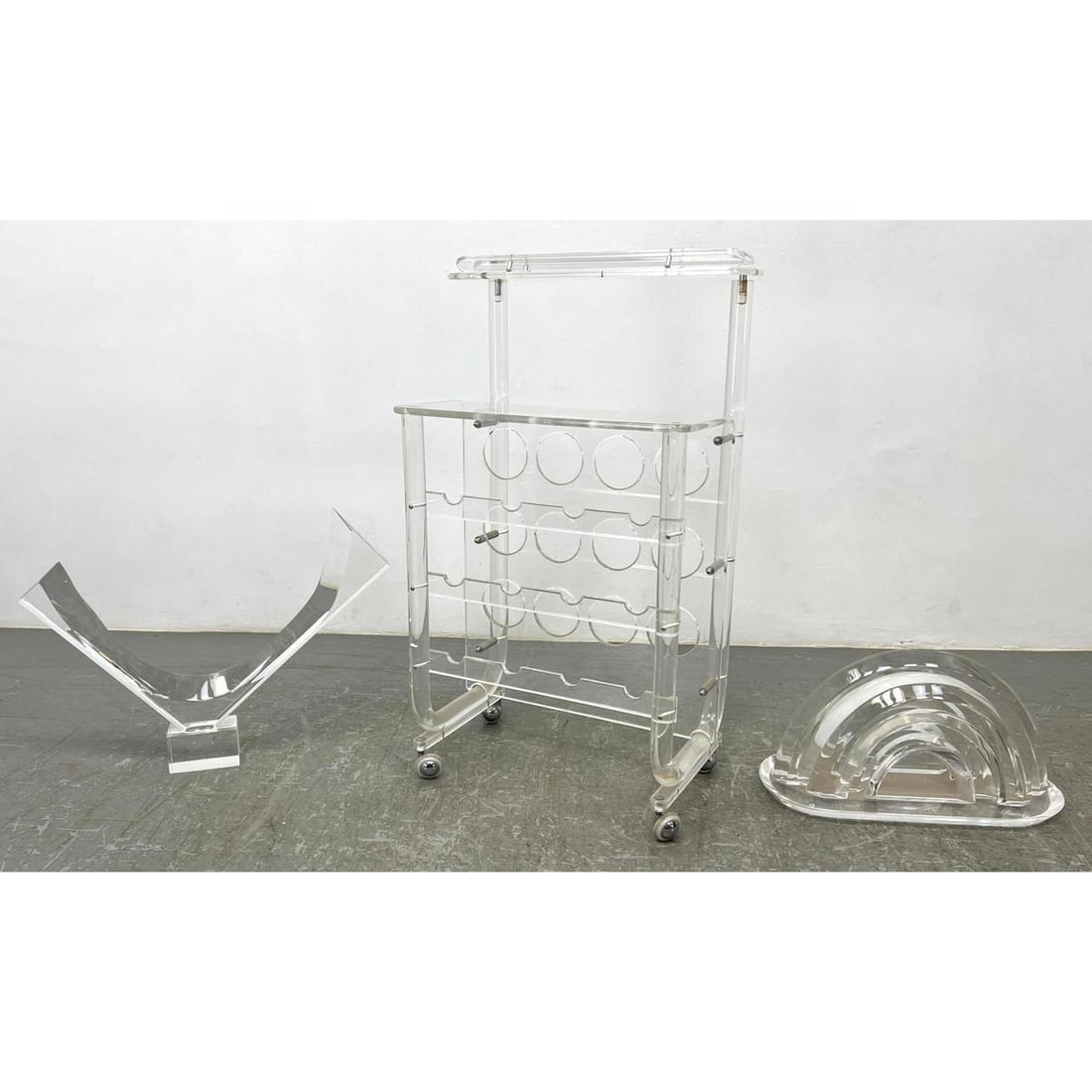 3pc Modernist Lucite Lot. 2 VAN TEAL Clear Acrylic Abstract Sculptures; each signed Van Teal. ALSO R: 3pc Modernist Lucite Lot. 2 VAN TEAL Clear Acrylic Abstract Sculptures; each signed Van Teal. ALSO Rolling Lucite Wine Rack (Floor Model). Dimensions: Height: 38 inches, Width: 20.5 inches, Depth: 15