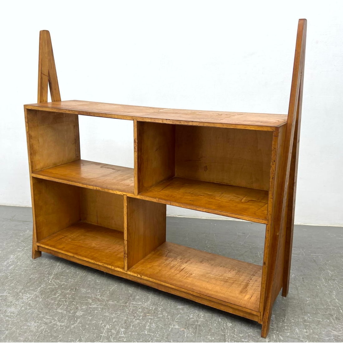 Modernist Book Case. Four Cubbies. Decorative Side Elements.: Modernist Book Case. Four Cubbies. Decorative Side Elements. Dimensions: Height: 46 inches, Width: 49.5 inches, Depth: 14 inches. --- - - We offer curbside delivery to NYC, Manhattan, Close Brooklyn, 