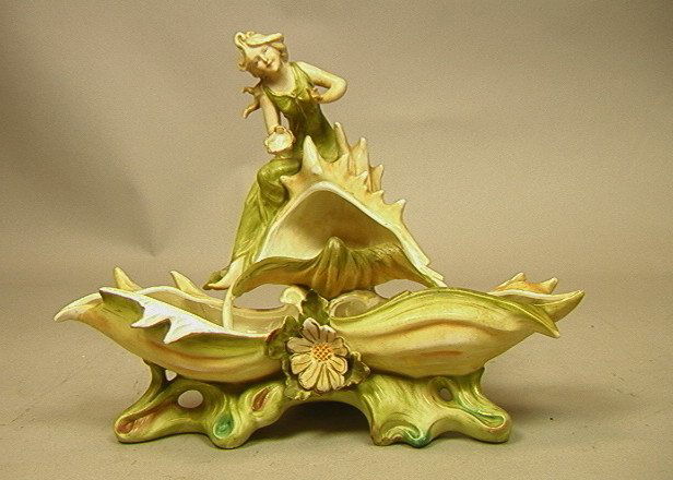AMPHORA Porcelain Figural Grouping. Woman with Se: AMPHORA Porcelain Figural Grouping. Woman with Sea Shell & Foliage. Unmarked.-- Dimensions: H: 10 inches: W: 12.5 inches: D: 6 inches ---