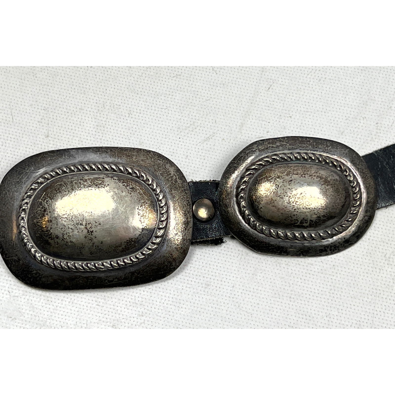 Signed AR Concho on Black Leather Belt. Large Buckle with Nine Oval Braided Trim Conchos. Signed AR. (1 of 4)