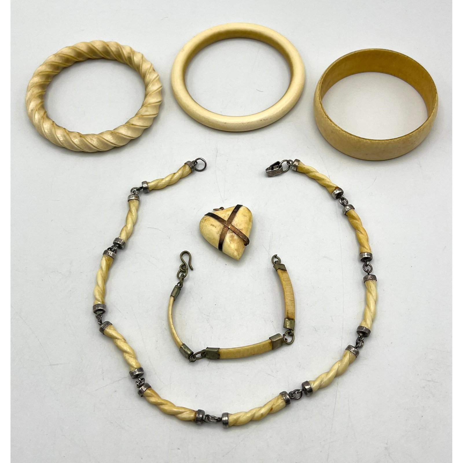 2pc Carved Material Bangle Bracelets; Heart Pendant. Also includes Several Carved links for partial: 2pc Carved Material Bangle Bracelets; Heart Pendant. Also includes Several Carved links for partial necklace. --- US Packing and Shipping charge: $35 Plus insurance at a rate of $1 per hundred.