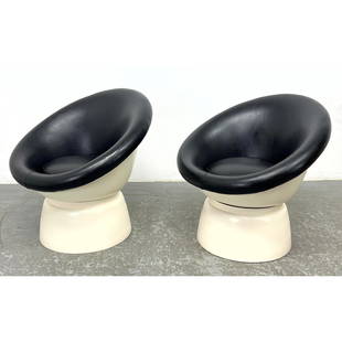 Pair of space age swiveling pod chairs with steel construction and black vinyl upholstery Molded Pl: Pair of space age swiveling pod chairs with steel construction and black vinyl upholstery Molded Plastic Modernist Lounge Chairs. Pedestal Bases with Hoop Form Black Vinyl Seats. Dimensions: Height: 2