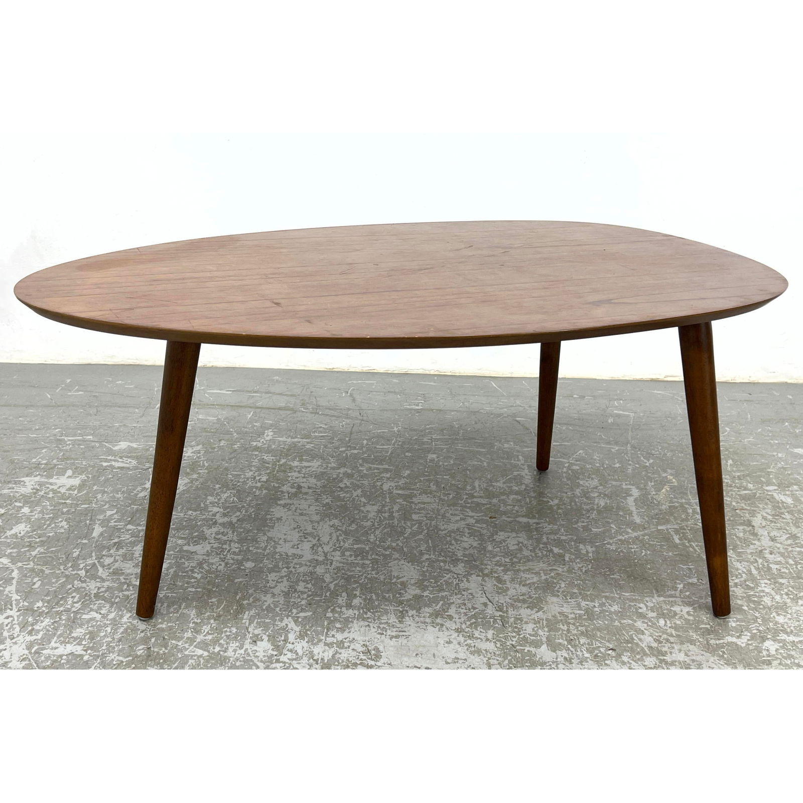 Tri Leg Modernist American Modern Coffee Table. Guitar Pick shaped top. Three tapered wood legs.: Tri Leg Modernist American Modern Coffee Table. Guitar Pick shaped top. Three tapered wood legs. Dimensions: Height: 18.5 inches, Width: 39.5 inches, Depth: 23.75 inches. --- - - We offer curbside del