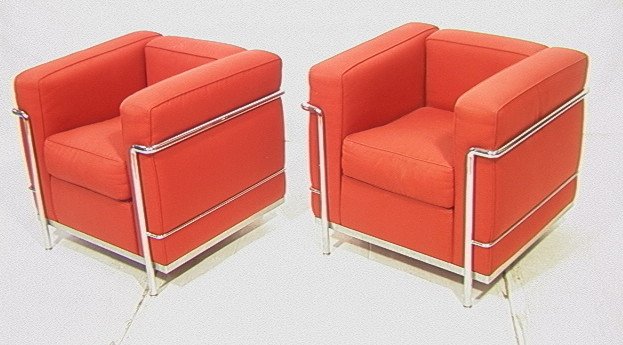 PR CASSINA Chrome Chairs. Le Corbusier LC2 Model.: PR CASSINA Chrome Chairs. Le Corbusier LC2 Model. Milano. Italy. Both signed and numbered under arm. Red fabric upholstery. Original store tags on rear of each chair.-- Dimensions: H: 27.5 inches: W: