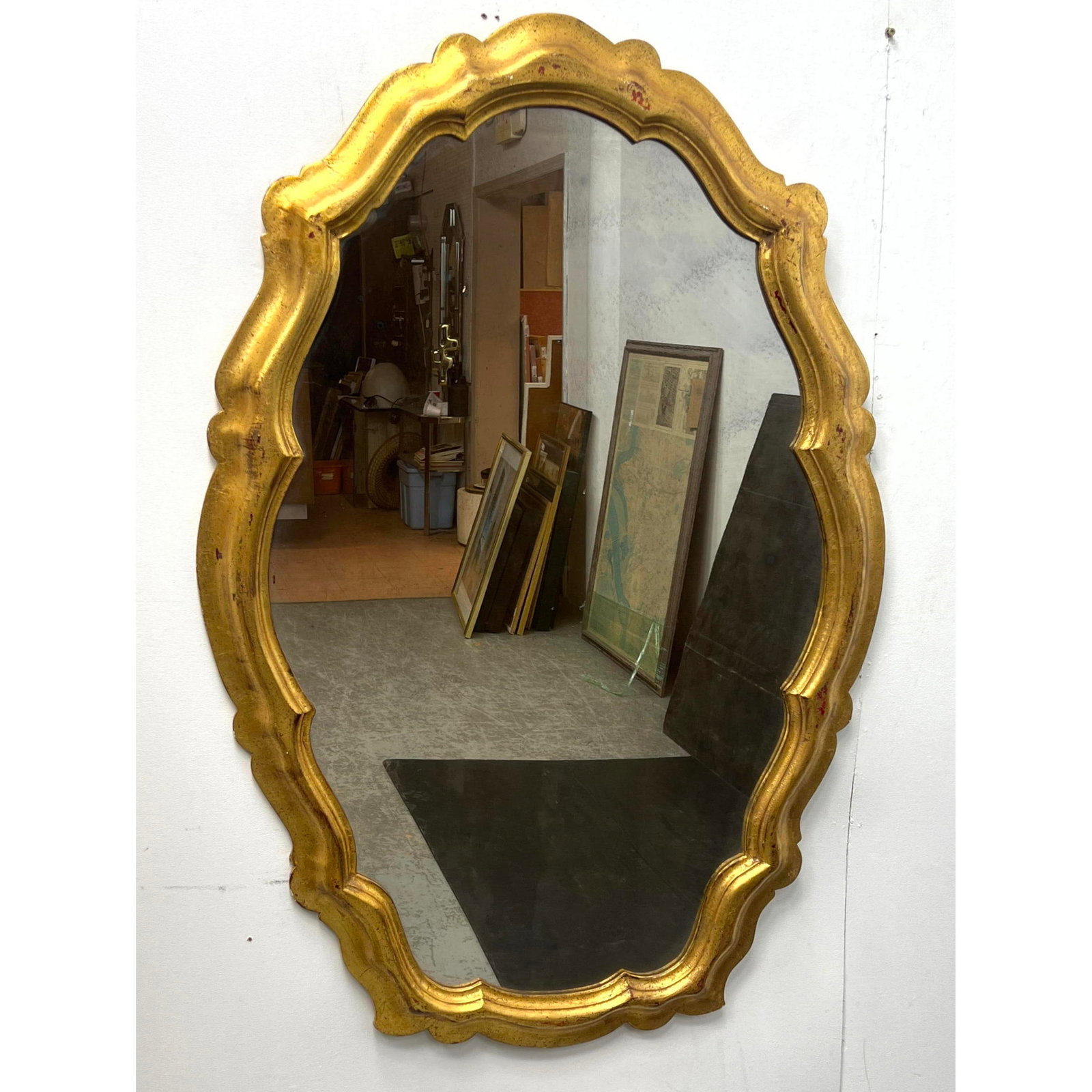 Italian Carved and Gilt Wall Mirror, Mid 20th century, paper Italian label en verso. Looking glass.: Italian Carved and Gilt Wall Mirror, Mid 20th century, paper Italian label en verso. Looking glass. Dimensions: Height: 47 inches, Width: 32.5 inches, Depth: 2 inches. --- - We offer curbside delivery