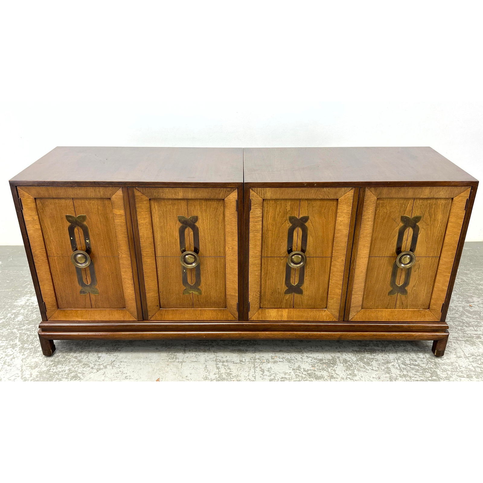 Double 2 Door Cabinets on Low Wood Platform Base. Antiqued Brass Hardware. RENZO RUTILLI Style: Double 2 Door Cabinets on Low Wood Platform Base. Antiqued Brass Hardware. RENZO RUTILLI Style Dimensions: Height: 31 inches, Width: 66 inches, Depth: 19 inches. --- - We offer curbside delivery for m