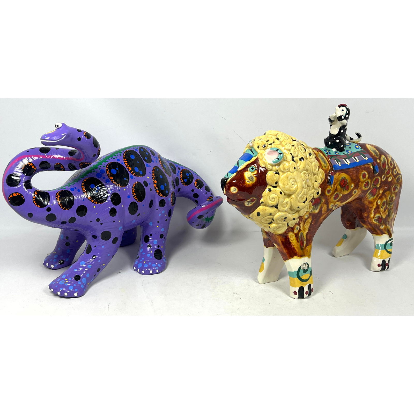 2pc Colorful Painted Artisan Studio Animals. Purple Polka Dot Brontosaurus, Signed. Lion with Monkey: 2pc Colorful Painted Artisan Studio Animals. Purple Polka Dot Brontosaurus, Signed. Lion with Monkey on Back. NEW Old Store Stock Stored from Closed Craft Gallery. Dimensions: Height: 13 inches, Width