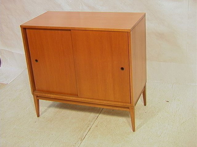 PAUL McCOBB Planner Group Walnut Two Door Cabinet: PAUL McCOBB Planner Group Walnut Two Door Cabinet. Sliding Door American Modern Cabinet with two interior shelves. Round metal hardware. Nice tapered square legs and stretcher. Marked. -- Dimensions: