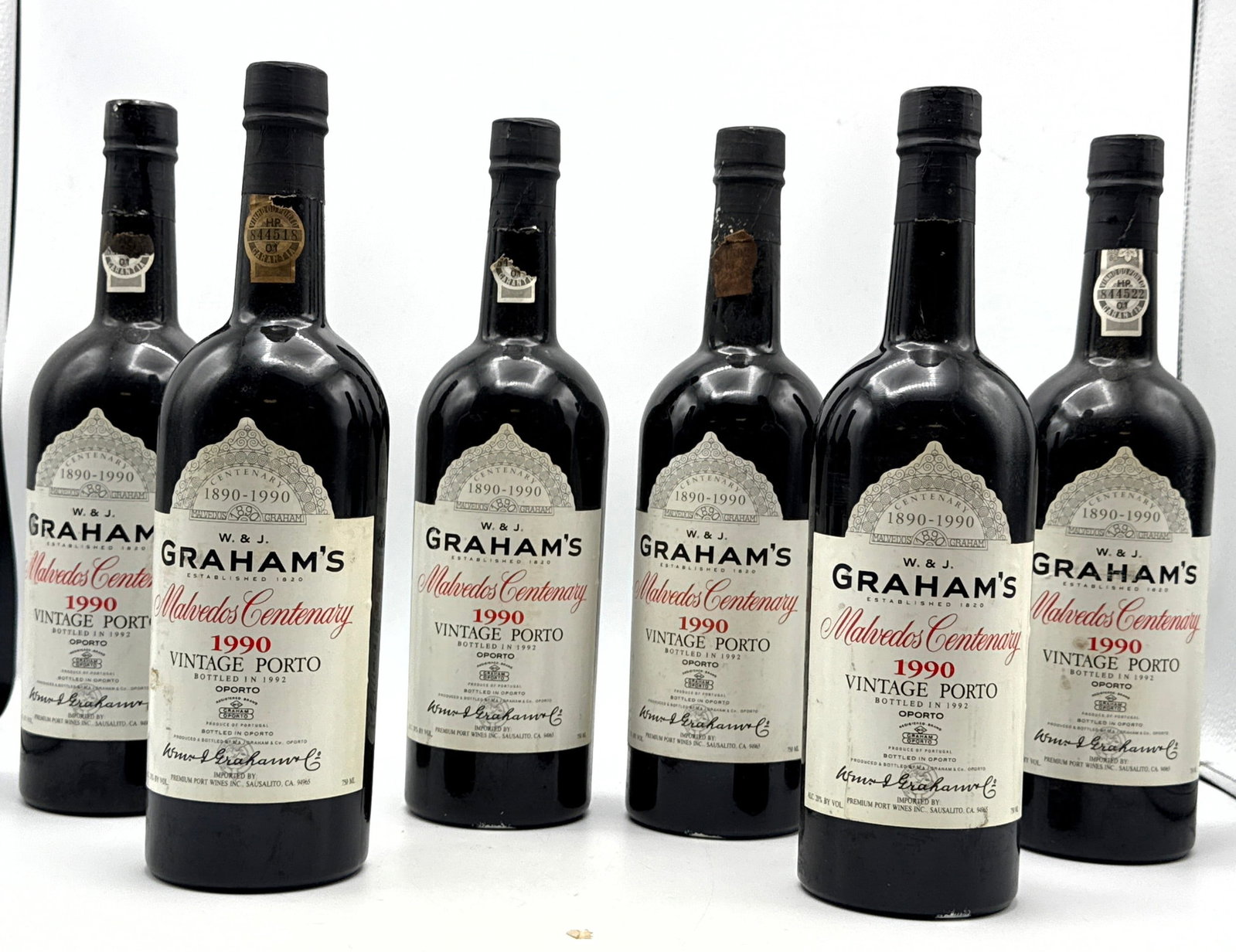 6 pcs - 1990 Graham Porto Centenary Malvedos Red - Fortified Wine. One bottle has a little leakage.: 6 pcs - 1990 Graham Porto Centenary Malvedos Red - Fortified Wine. One bottle has a little leakage. Dimensions: Height: 12 inches, Width: inches. --- Buyers are encouraged to pick up their purchases d
