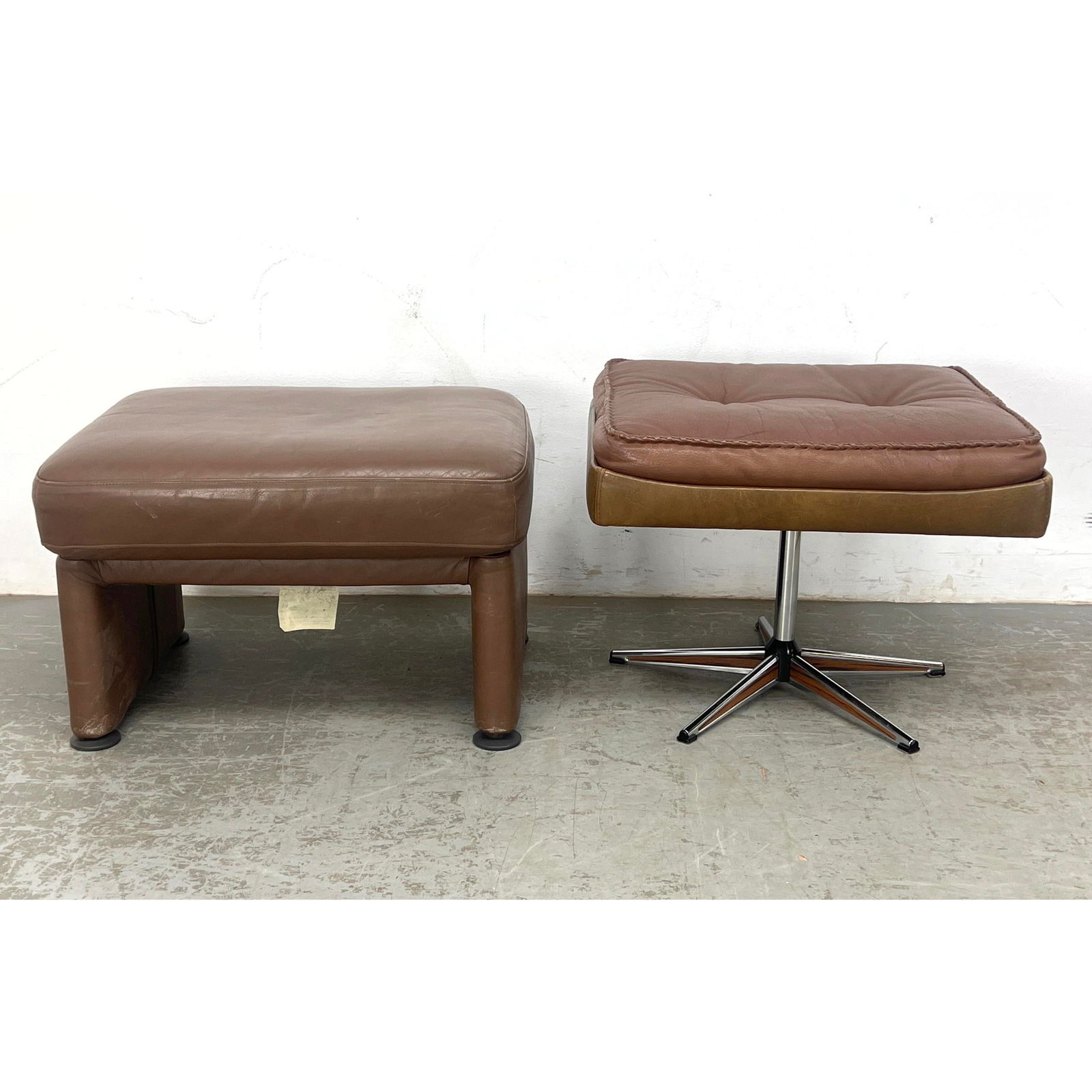 2pcs. Mid century modern stools. Brown Leather ottomans or footstools. 1 is Cy Mann.: 2pcs. Mid century modern stools. Brown Leather ottomans or footstools. 1 is Cy Mann. Dimensions: Height: 18 inches, Width: 23 inches, Depth: 19 inches. --- - We offer curbside delivery for most items