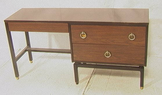 EDWARD WORMLEY for DUNBAR Desk. 3 Drawer Desk wit: EDWARD WORMLEY for DUNBAR Desk. 3 Drawer Desk with dark trim border. Metal ring pulls. Light and dark wood laminate. Metal Dunbar tag. Branded IHSC mark.-- Dimensions: H: 29 inches: D: 18 inches: L: 6