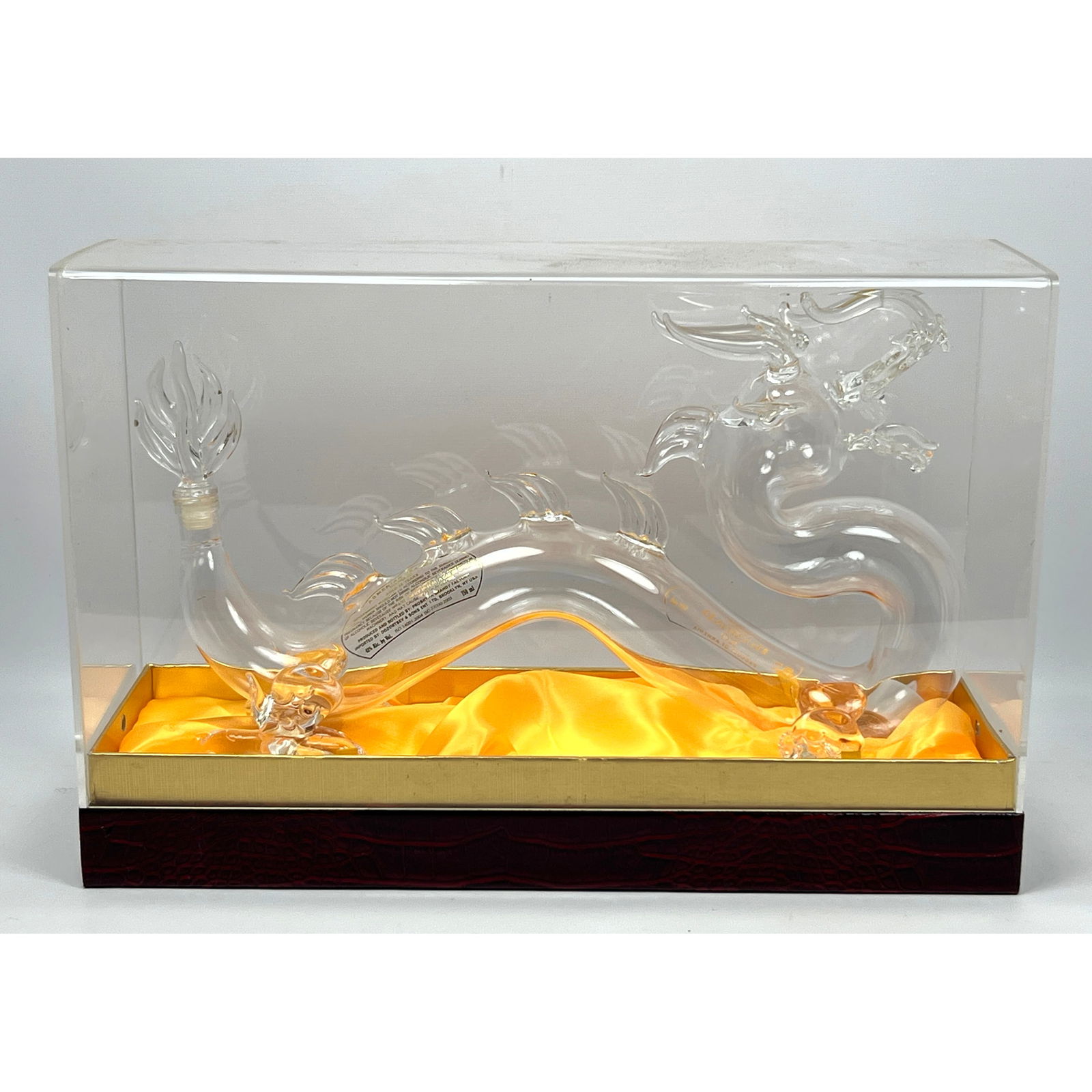 Clear glass decanter, intricately formed in the style of Asian dragon, featuring a serpentine body a: Clear glass decanter, intricately formed in the style of Asian dragon, featuring a serpentine body and a flame-like tail sealed with a cork. The bottle, originally containing "ARMENIAN BRANDY DIAMOND