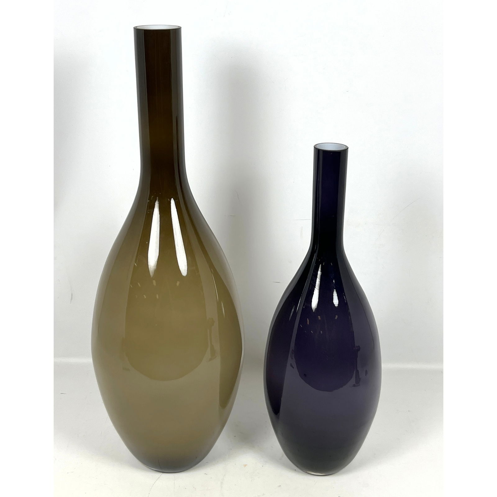 2pc Cased Glass Slender Neck Vases. Tallest is taupe color. Smaller is Amethyst color.: 2pc Cased Glass Slender Neck Vases. Tallest is taupe color. Smaller is Amethyst color. Dimensions: Height: 26 inches, Width: 7 inches, Depth: 7 inches. - Additional Dimensions: Dark purple H: 20 inche