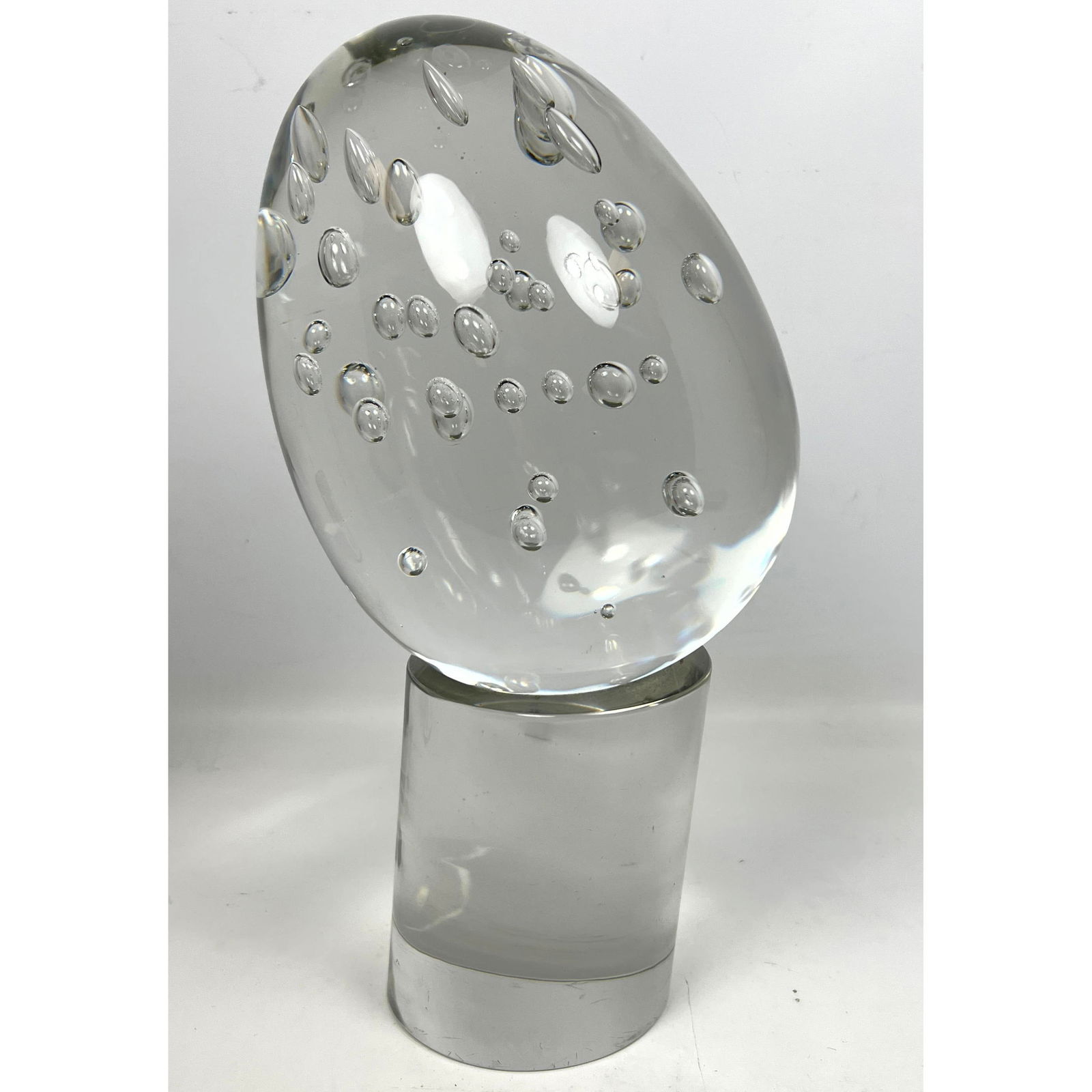Clear Art Glass Modernist Sculpture. Elliptical Egg Form with internal bubbles rests on tilted clear (1 of 8)