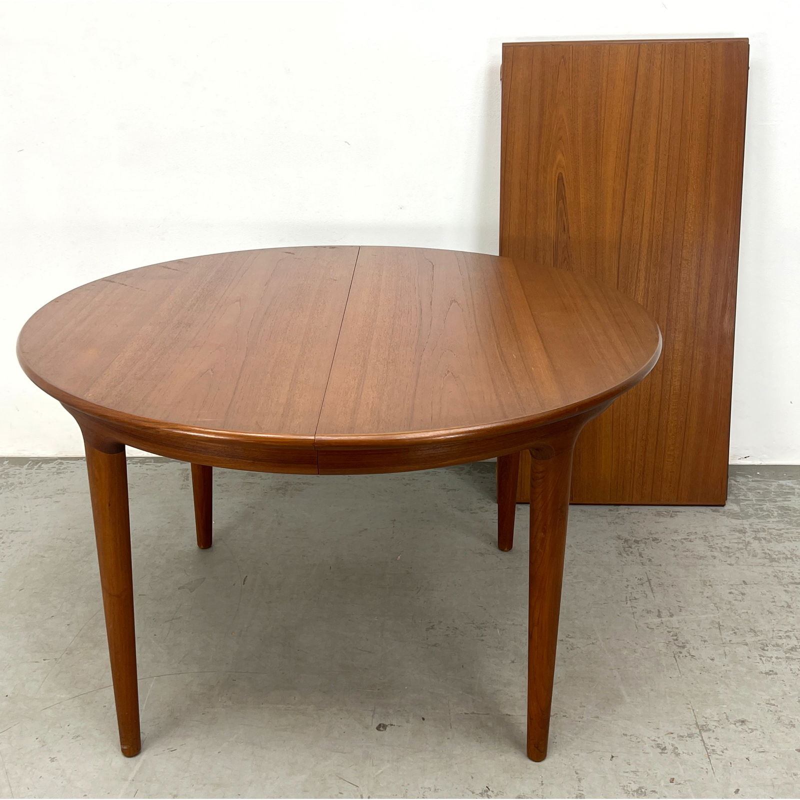 JOHANNES ANDERSEN Danish Teak Dining Table. Round Modern Table. ULDUM MOBELFABRIK Foil Label.: JOHANNES ANDERSEN Danish Teak Dining Table. Round Modern Table. ULDUM MOBELFABRIK Foil Label. . Includes: 1 - 23.5 inch leaf Dimensions: Height: 28.5 inches, Width: 47 inches, Depth: 47 inches. --- -