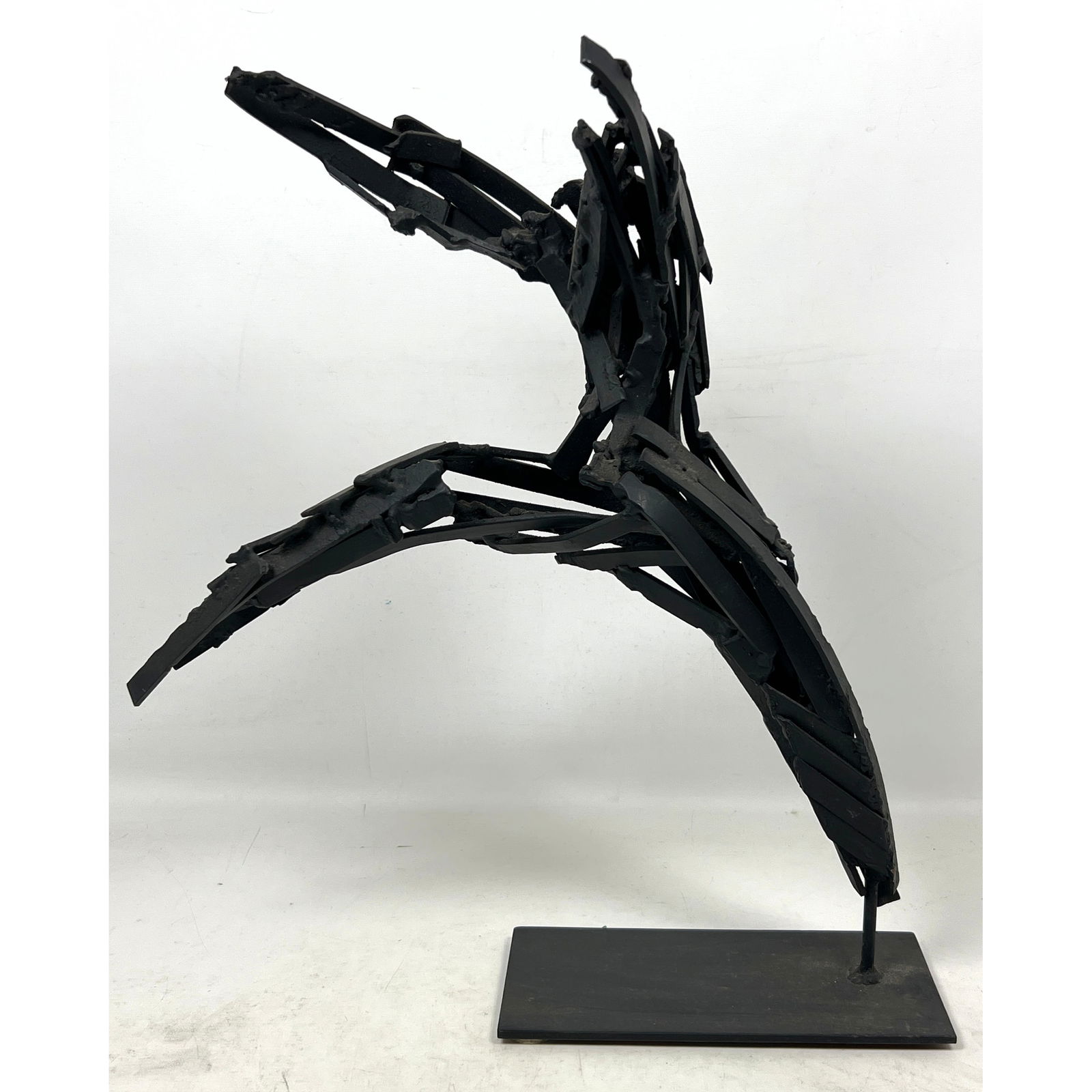 Brutalist Welded Metal Modernist Sculpture. Small Flat Metal Pieces Welded and Painted Black. Clever: Brutalist Welded Metal Modernist Sculpture. Small Flat Metal Pieces Welded and Painted Black. Cleverly Balanced on Metal Plate Base. No signature found. Dimensions: Height: 17 inches, Width: 15