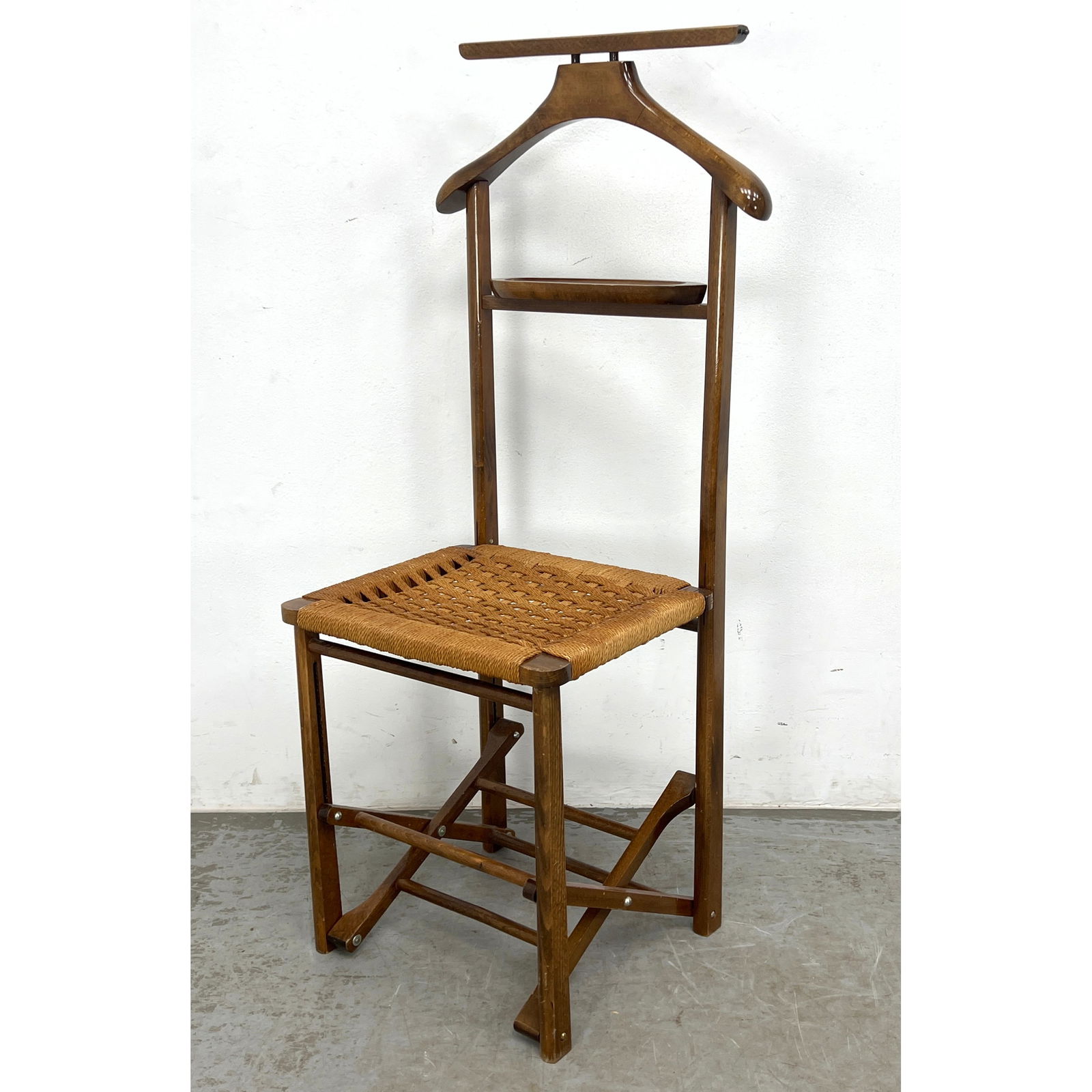 60s Vintage Italian Fratelli Reguitti Folding Valet Chair with dark stained beechwood frame and wove: 60s Vintage Italian Fratelli Reguitti Folding Valet Chair with dark stained beechwood frame and woven paper cord seat. Brande Italy. Dimensions: Height: 44 inches, Width: 16.25 inches, Depth: 15