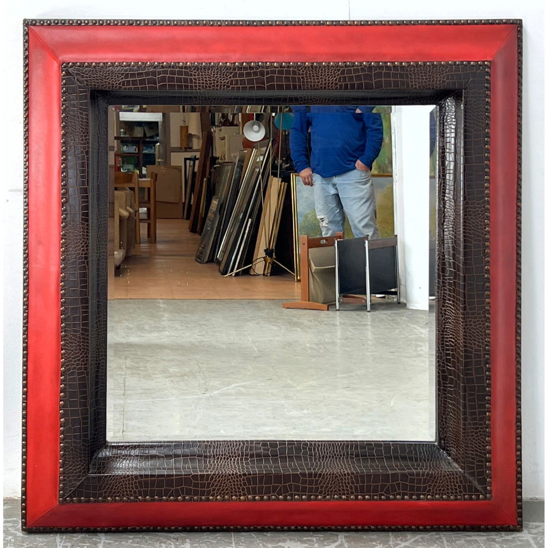HOWARD ELLIOT Faux Reptile Skin Square Wall Mirror. Multi layer frame consists of red faux leather a: HOWARD ELLIOT Faux Reptile Skin Square Wall Mirror. Multi layer frame consists of red faux leather and brown faux crocodile with rows of decorative brass tacks. Label. Dimensions: Height: 44 inches, W