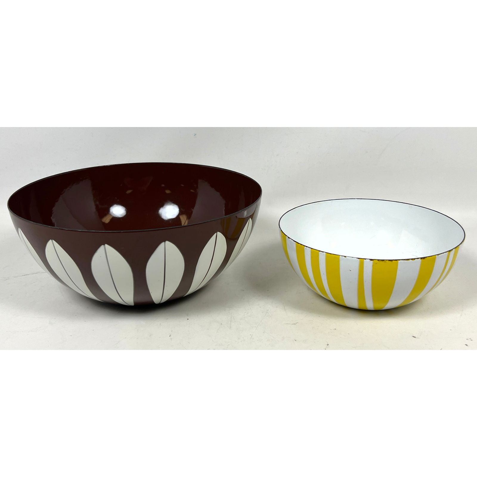 2pc CATHERINEHOLM Norway Enamel Bowls. 1). Brown Lotus Bowl with White Petals. Marked. 2). White Bow: 2pc CATHERINEHOLM Norway Enamel Bowls. 1). Brown Lotus Bowl with White Petals. Marked. 2). White Bowl with Bold Yellow Stripes. GRETE PRYTZ KITTELSEN, designer. Dimensions: Height: 4.75 inches, Width: