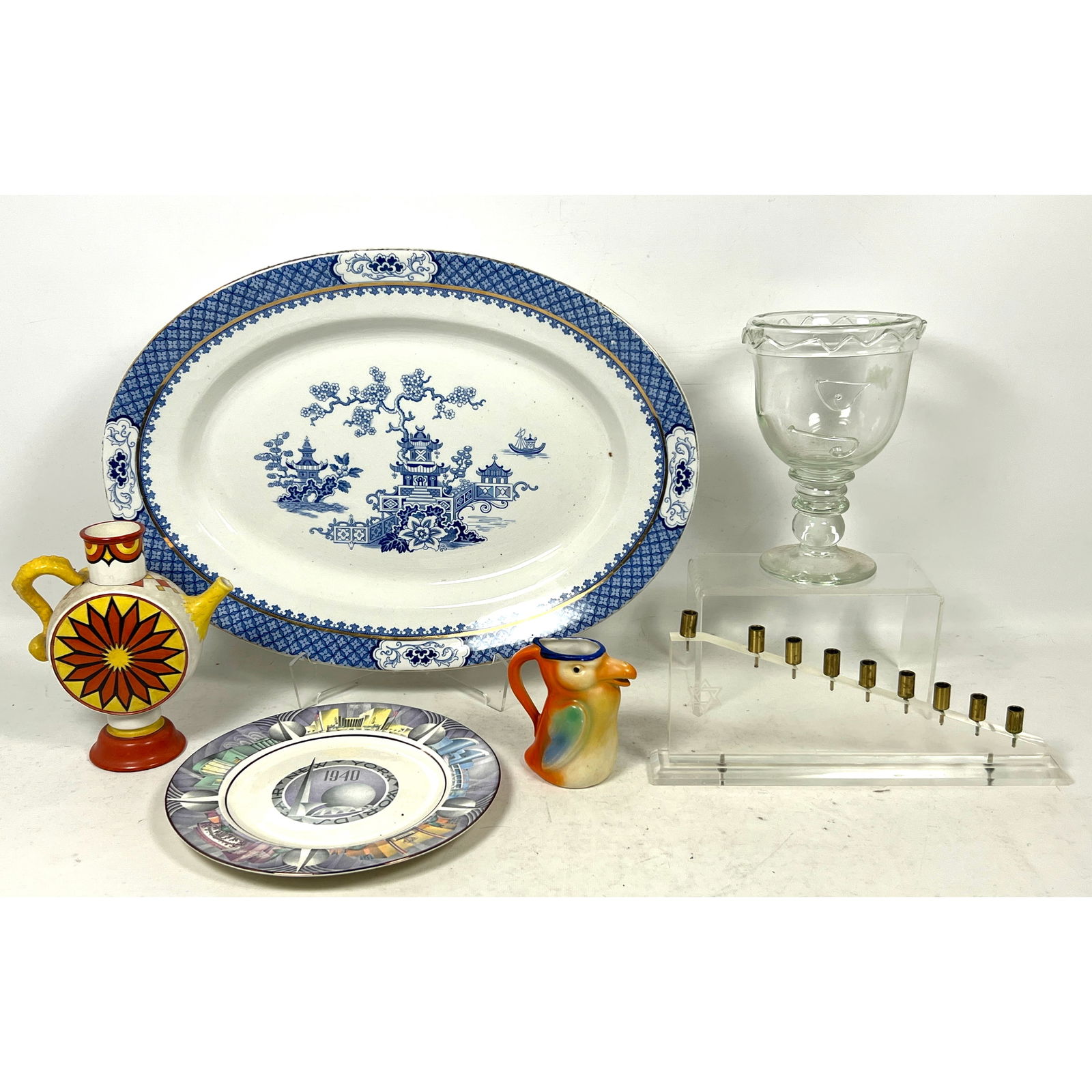 Shelf Lot. 1940 NYWF Homer Laughlin plate. After Blue Willow Serving Platter. Czech Bird Creamer. AR: Shelf Lot. 1940 NYWF Homer Laughlin plate. After Blue Willow Serving Platter. Czech Bird Creamer. ARABIA Finland Vase, MCM Lucite Menorah. Stem Glass Dimensions: Height: 2 inches, Width: 20.5 inches,