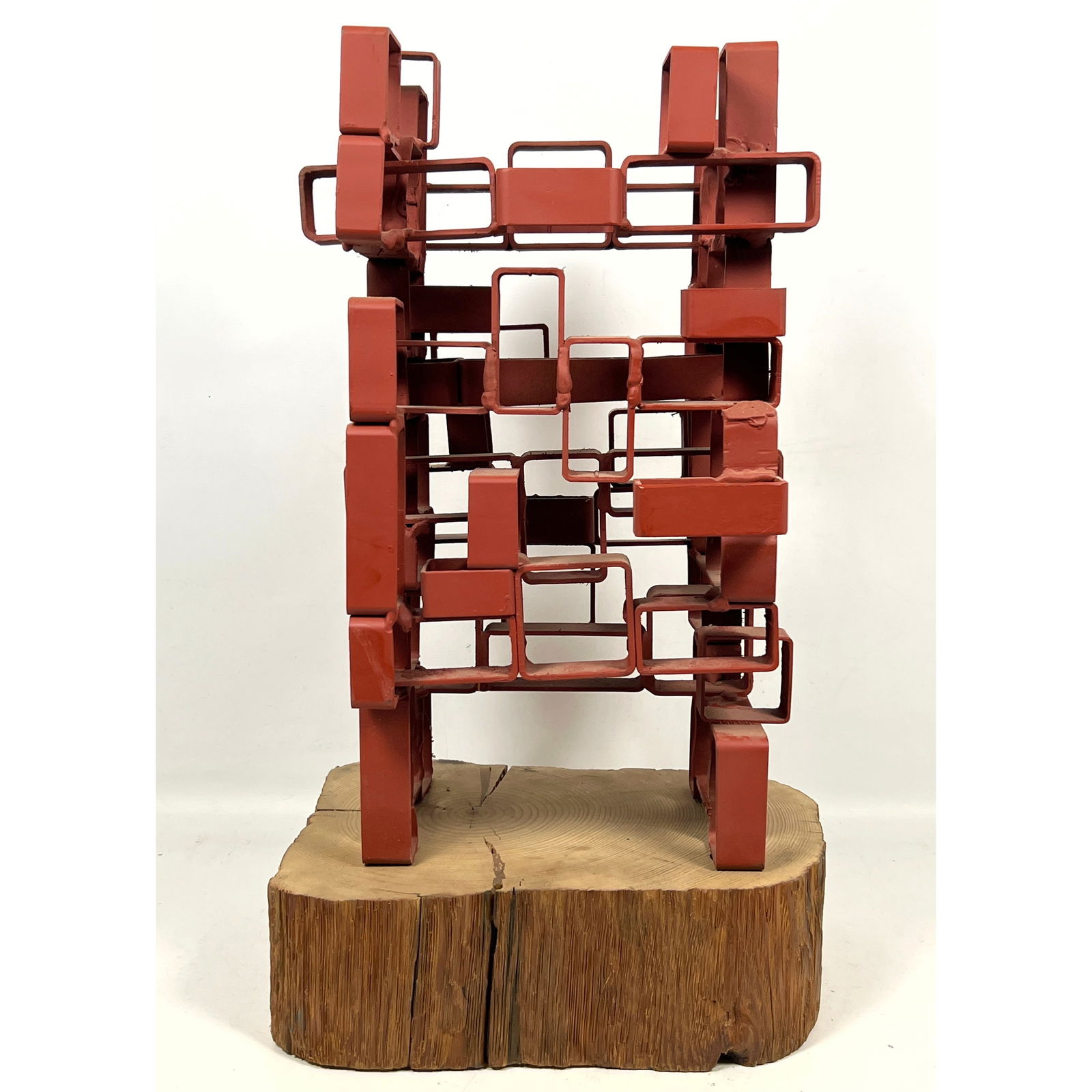 JOSEPH SELTZER Industrial Welded Metal Sculpture. Painted form mounted on natural wood slab base. Ar: JOSEPH SELTZER Industrial Welded Metal Sculpture. Painted form mounted on natural wood slab base. Artist signed. Joe Seltzer created "Red Tower" by welding sections of square and rectangular steel pip