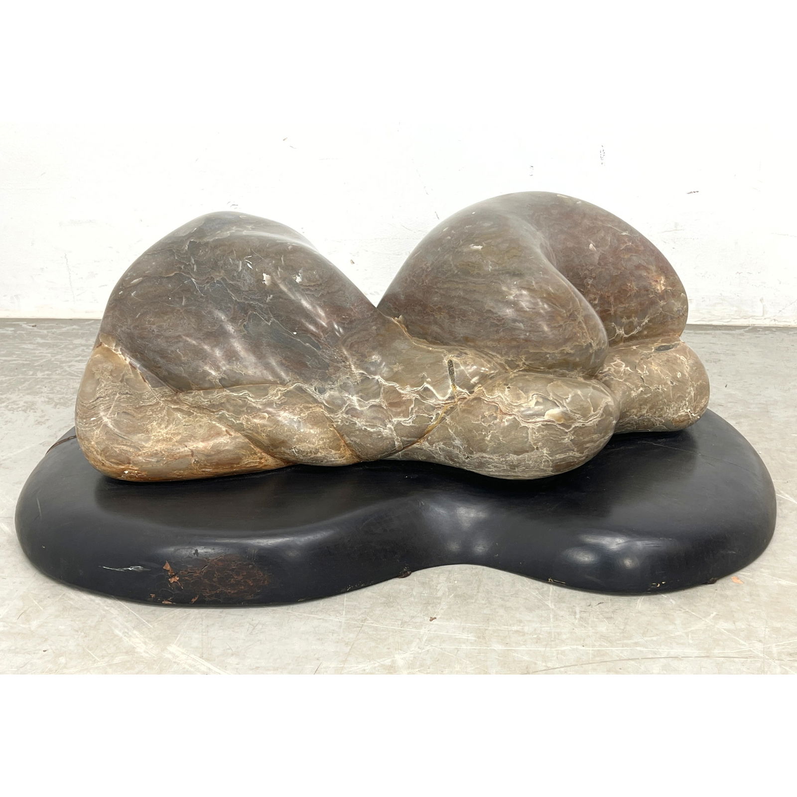 Large Modernist Organic Carved Stone Sculpture. Abstract form on black wood base. No signature found: Large Modernist Organic Carved Stone Sculpture. Abstract form on black wood base. No signature found. Dimensions: Height: 12 inches, Width: 35 inches, Depth: 27 inches. ---