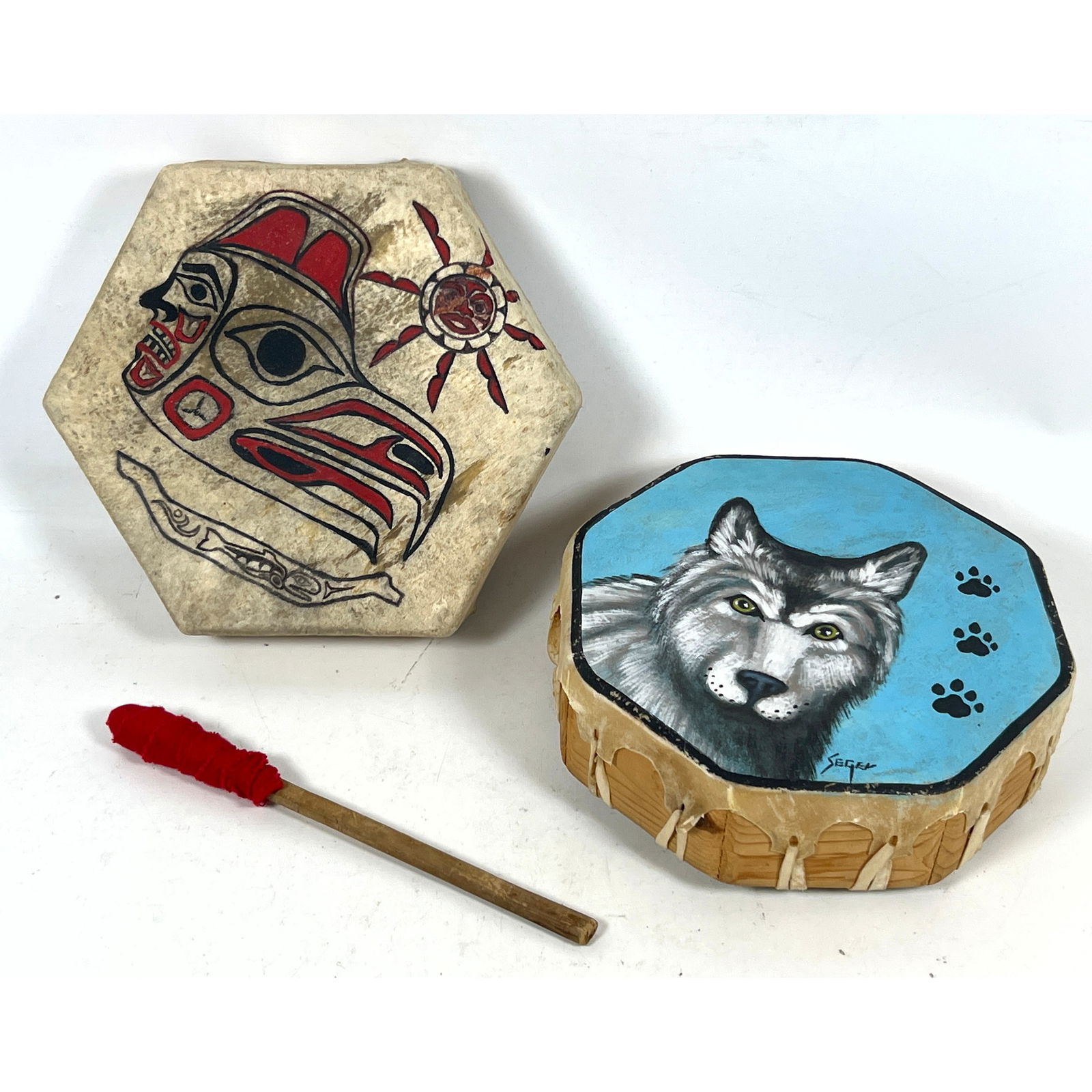 2pc Hand Painted Drums. 1) GERRY MORRIS Pacific Northwest Indian Drum, Rawhide stretched over wood f: 2pc Hand Painted Drums. 1) GERRY MORRIS Pacific Northwest Indian Drum, Rawhide stretched over wood frame. Signed. 2) SEGER Signed Drum with Wolf Head and Paw Print Images. Signed. Dimensions: Height: