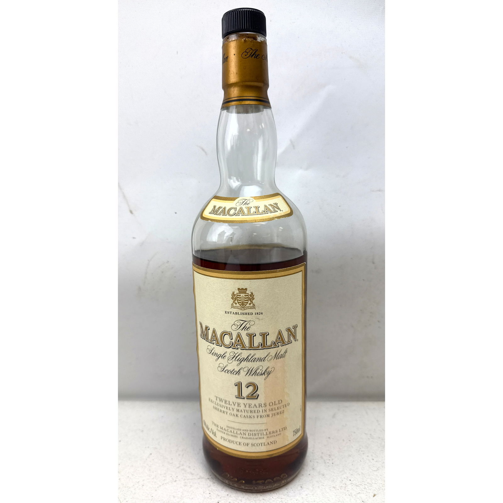 The Macallan 12 Year Old Single Highland Malt Scotch Whisky. Opened and only partially filled.: The Macallan 12 Year Old Single Highland Malt Scotch Whisky. Opened and only partially filled. Dimensions: Height: 12 inches, Width: 3 inches, Depth: 3 inches. ---