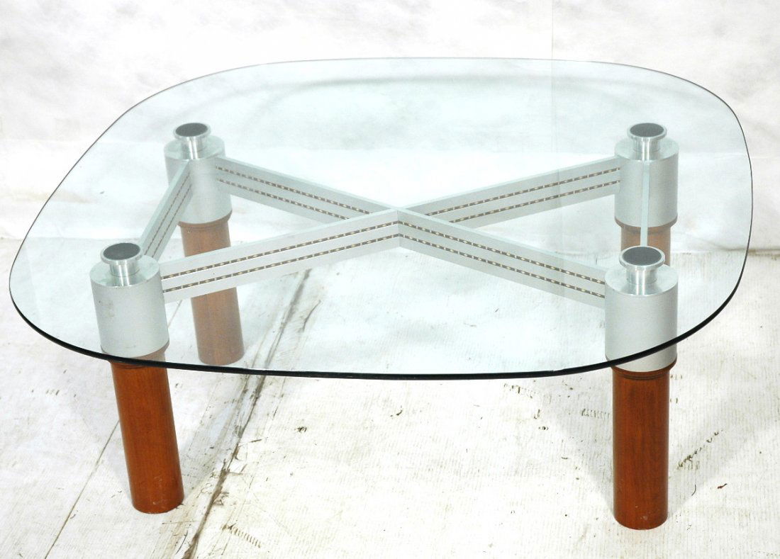 KAISER NEWMAN Stainless & Glass Coffee Table. Thi: KAISER NEWMAN Stainless & Glass Coffee Table. Thick wood column legs capped with stainless. Perforated stainless "X" stretcher. Rounded 1/4" thick glass top. Architectural form.-- Dimensions: H: 17.75