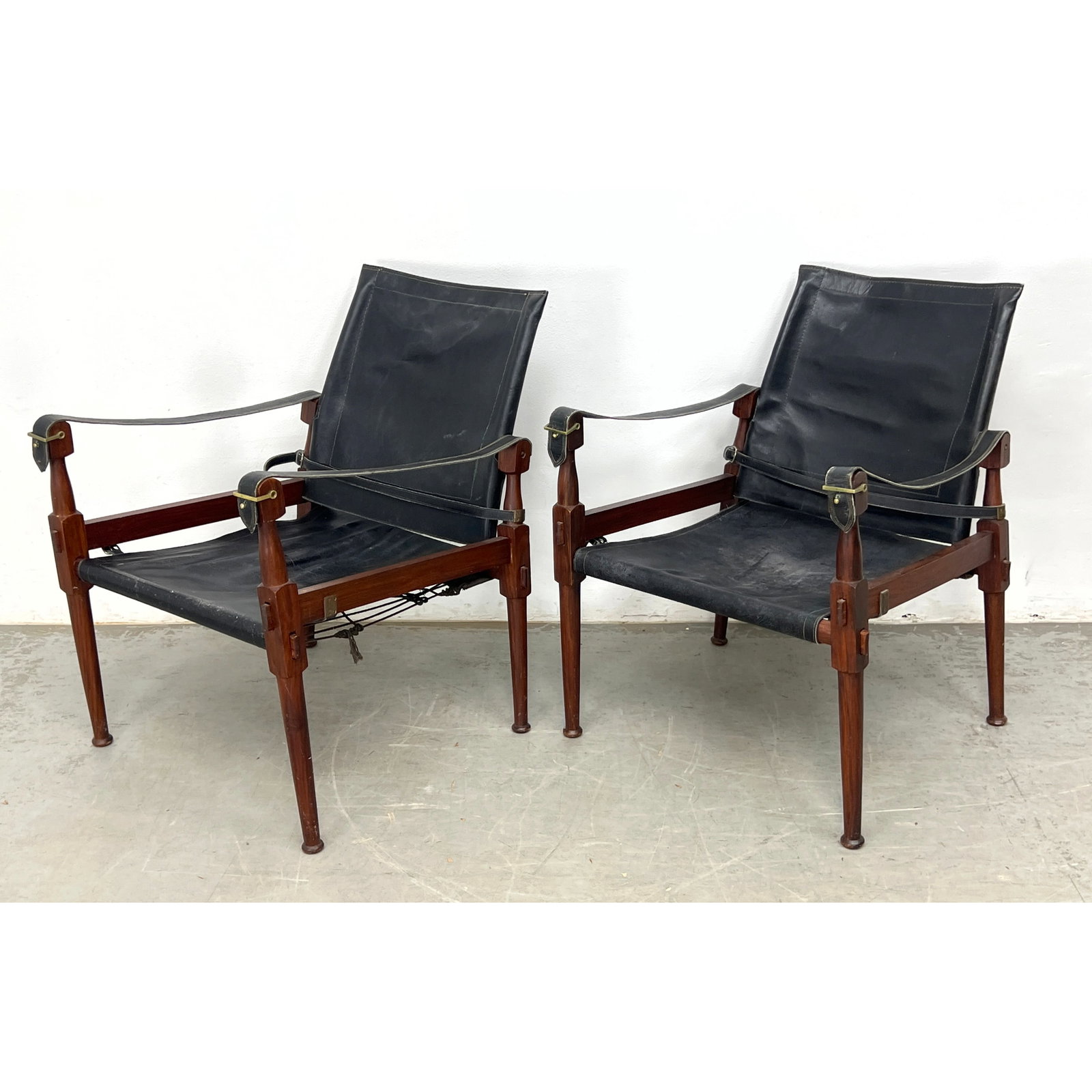 Pair of mid-century 'Roorkee' safari campaign chairs with carved walnut rosewood stain frames and bl: Pair of mid-century 'Roorkee' safari campaign chairs with carved walnut rosewood stain frames and black leather sling seats, Dimensions: Height: 30 inches, Width: 22 inches, Depth: 29 inches. - Seat H