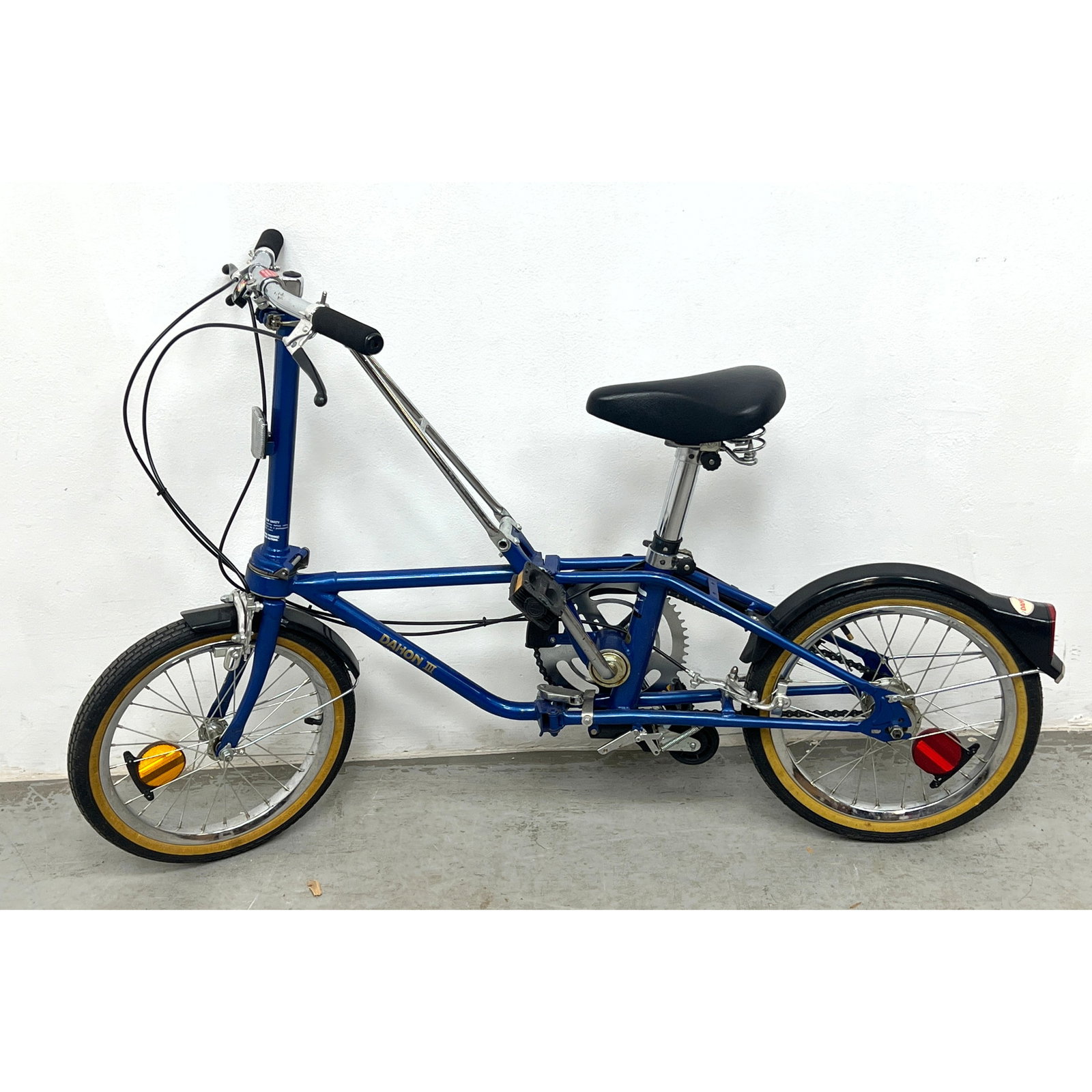 Vintage Dahon III folding bicycle features a blue painted frame and is equipped with a three-speed S: Vintage Dahon III folding bicycle features a blue painted frame and is equipped with a three-speed Sturmey Archer internal gear hub. Dimensions: Height: 32 inches, Width: 19 inches, Depth: 53 inches.