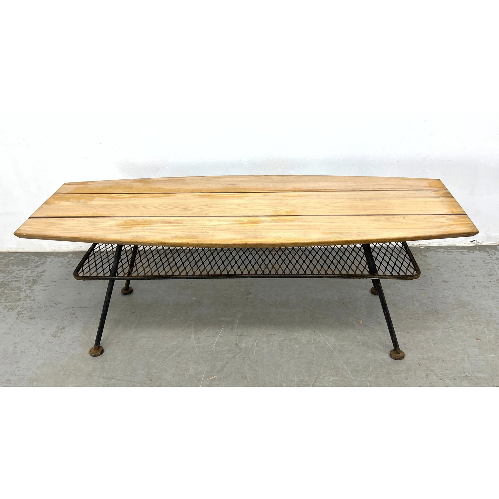 Arthur Umanoff attributed Surfboard Cocktail Table, Iron Base, with Wire Lower Tier: Arthur Umanoff attributed Surfboard Cocktail Table, Iron Base, with Wire Lower Tier Dimensions: Height: 17 inches, Width: 50 inches, Depth: 20.5 inches. ---