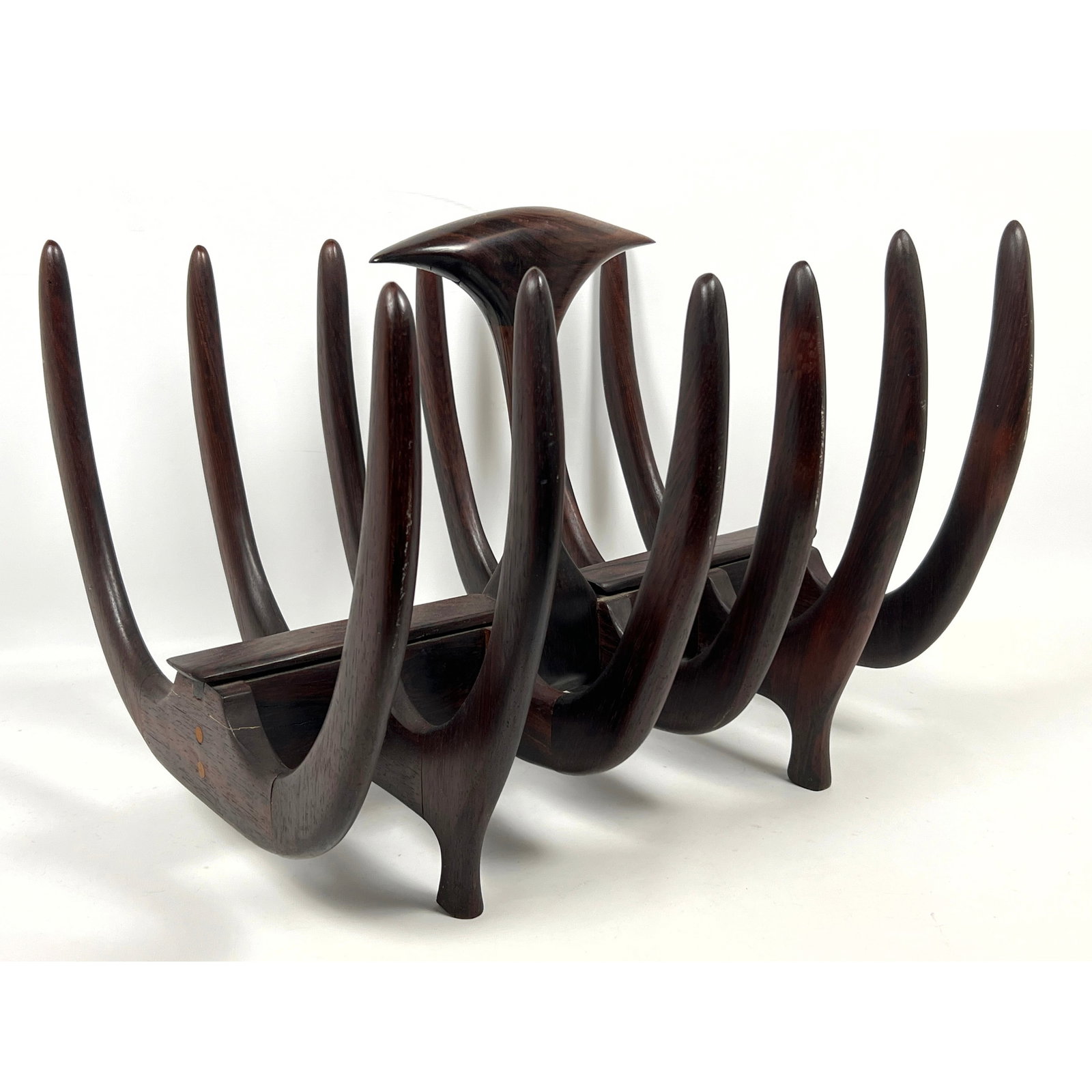Mid Century Modern Rib Motif Magazine Rack. Sculptural Rosewood form. Rows of Bowed "Ribs" connect t: Mid Century Modern Rib Motif Magazine Rack. Sculptural Rosewood form. Rows of Bowed "Ribs" connect to Central Element. Organic Upright Handle. No Marks found. Dimensions: Height: 15 inches, Width: 15 