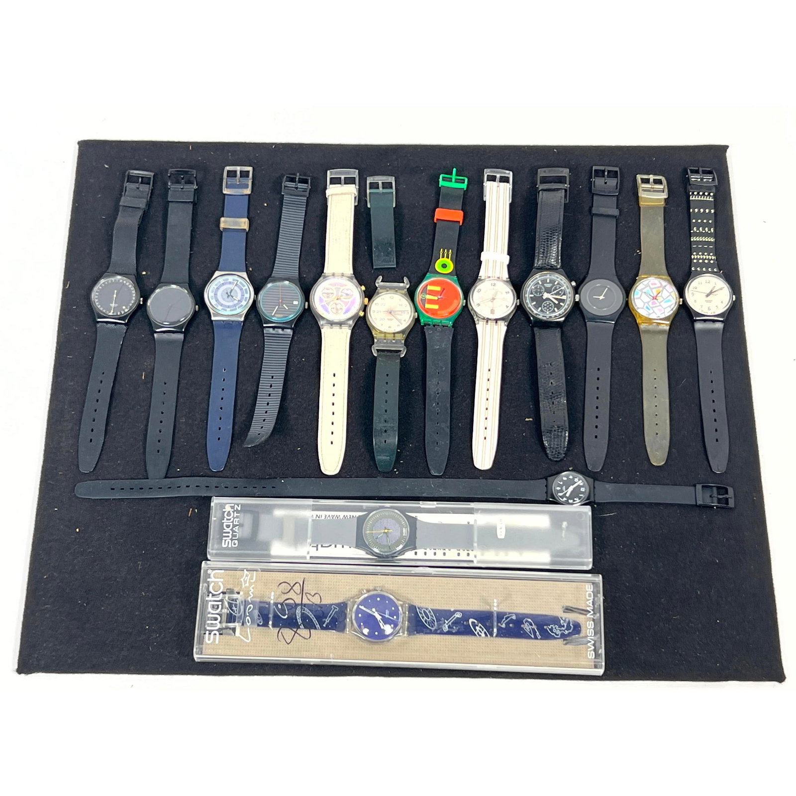 Assortment of 15 Swatch wristwatches with quartz movements, featuring a variety of designs primarily: Assortment of 15 Swatch wristwatches with quartz movements, featuring a variety of designs primarily from the 1980s and 1990s Dimensions: Height: 9 inches, Width: 1.5 inches, Depth: 1.5 inches. ---
