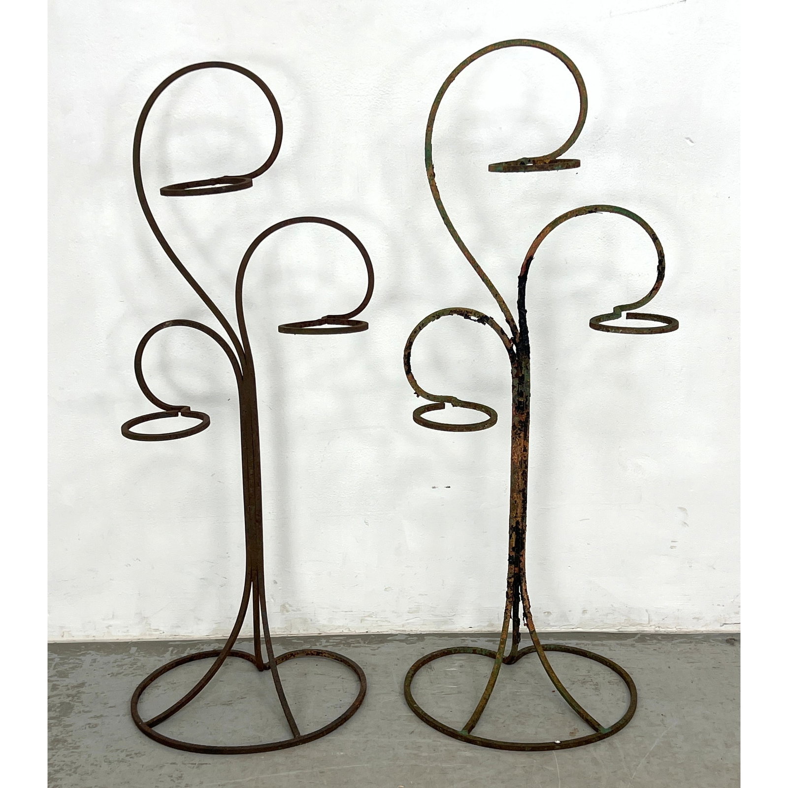 Pair of multi-tier floor-standing plant holders made from wrought iron.: Pair of multi-tier floor-standing plant holders made from wrought iron. Dimensions: Height: 42.5 inches, Width: 17 inches, Depth: 14.5 inches. ---