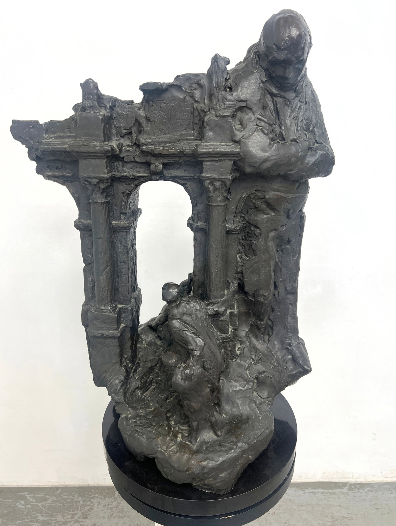 Stanley Bleifeld "The Legacy" expressionistic cast bronze sculpture titled Large standing figure vie: Stanley Bleifeld "The Legacy" expressionistic cast bronze sculpture titled Large standing figure views architectural arch with smaller figures. Initialed and dated. Mounted on a black painted round