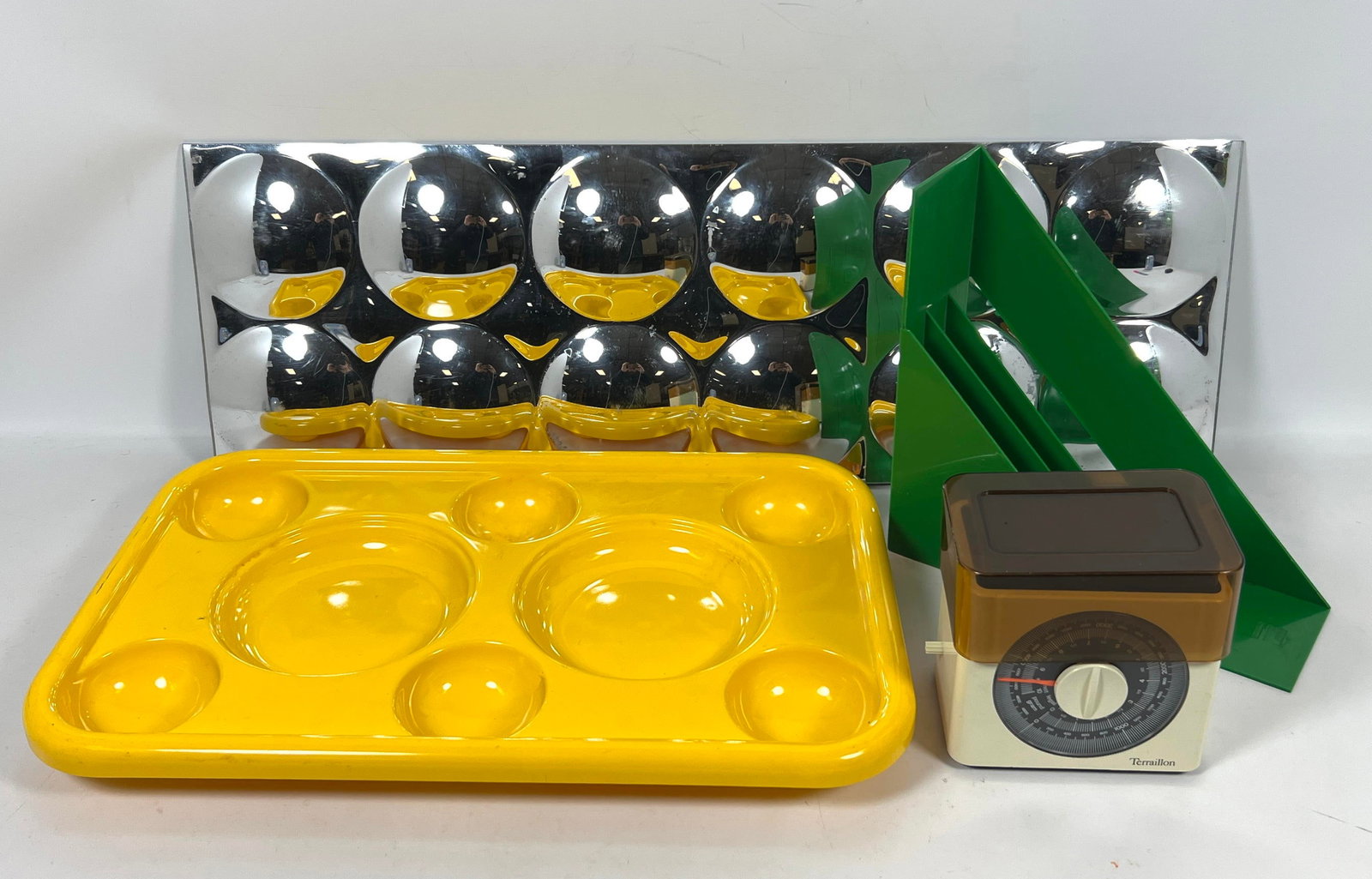 Mid Century Modern Lot. 1970s Space Age grouping featuring a chrome modular bubble mirror, a bright: Mid Century Modern Lot. 1970s Space Age grouping featuring a chrome modular bubble mirror, a bright yellow plastic tray, green plastic magazine racks, and a Terraillon kitchen scale. Dimensions: Heigh