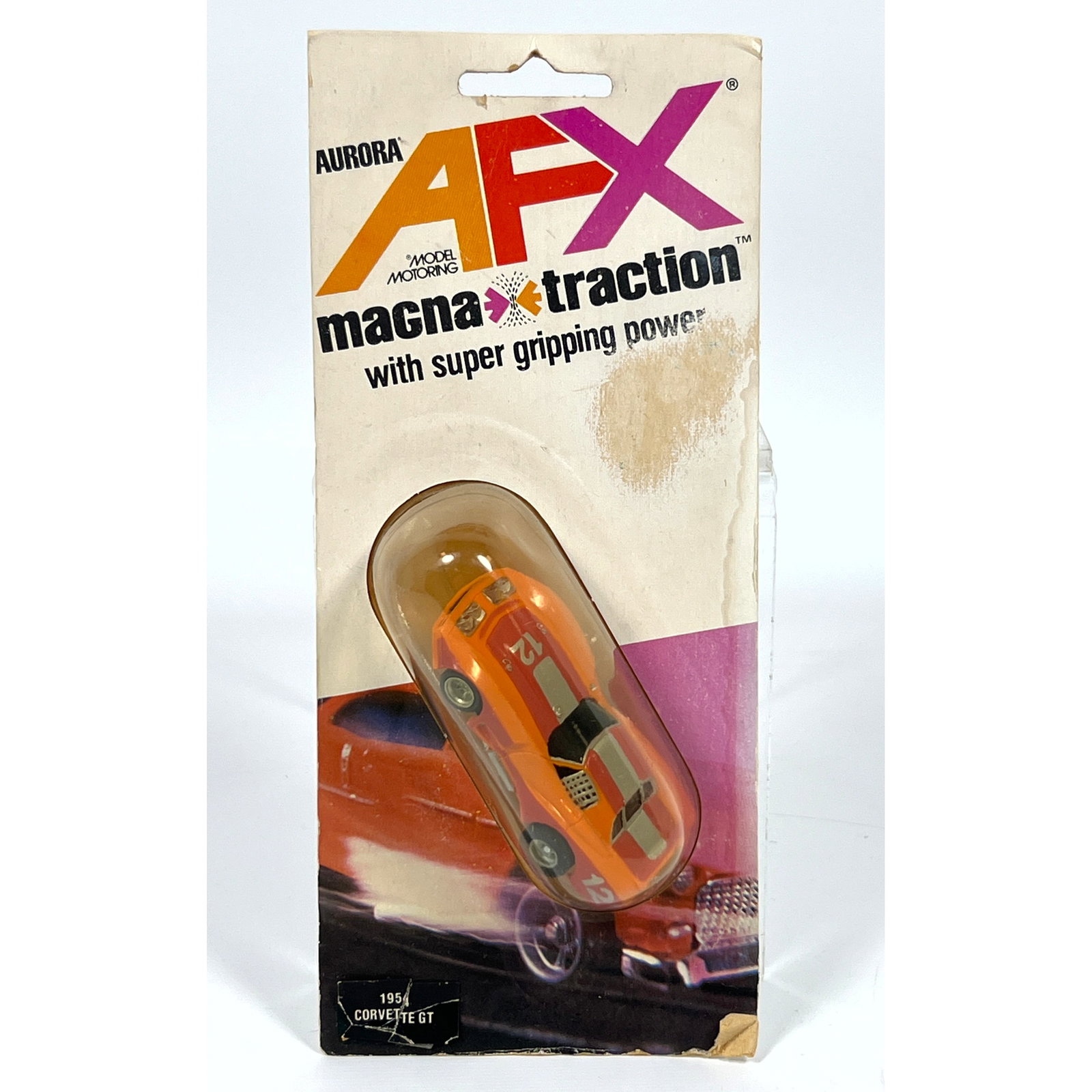 Aurora AFX Magna-Traction HO scale electric slot car features a plastic Corvette GT body on a metal: Aurora AFX Magna-Traction HO scale electric slot car features a plastic Corvette GT body on a metal and plastic chassis. The vehicle is finished in orange paint with a silver-gray center stripe outlin