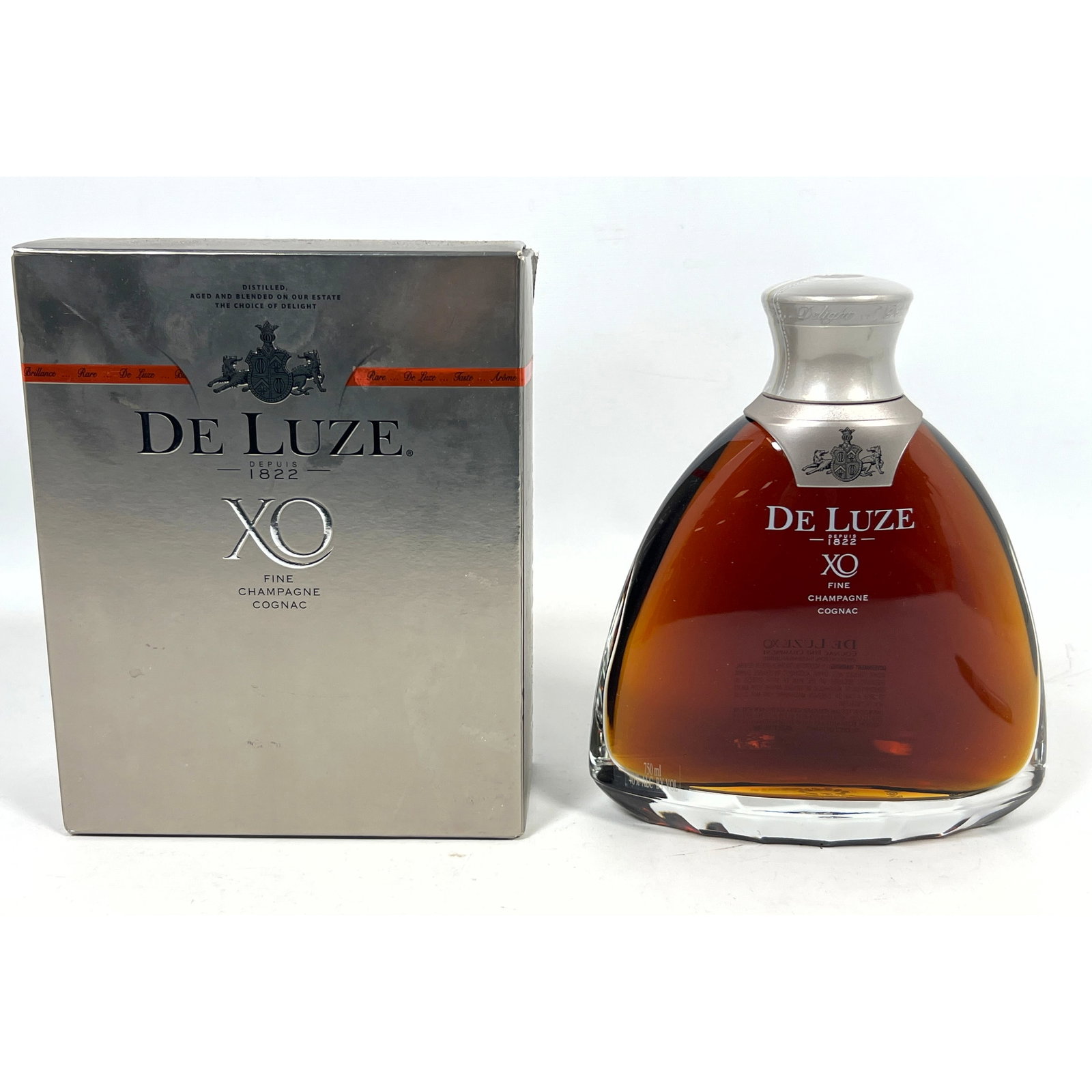 De Luze XO Fine Champagne Cognac, presented in its original silver-toned cardboard presentation box.: De Luze XO Fine Champagne Cognac, presented in its original silver-toned cardboard presentation box. Dimensions: Height: 10 inches, Width: 6 inches, Depth: 3 inches. ---
