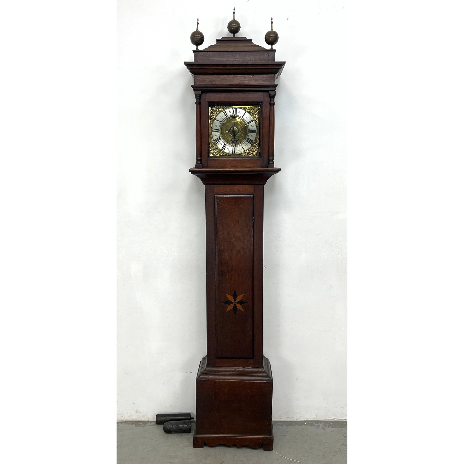 Antique Wm Hazelcline Georgian eight-day long tall case clock featuring a quarter-sawn oak case. The: Antique Wm Hazelcline Georgian eight-day long tall case clock featuring a quarter-sawn oak case. The hood is designed with a caddy top surmounted by three brass globe-and-spire finials and supported