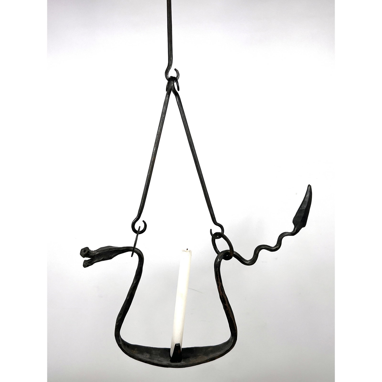 F BAU Hand-wrought iron hanging candle holder features a folk art design incorporating dragon zoomor: F BAU Hand-wrought iron hanging candle holder features a folk art design incorporating dragon zoomorphic elements. Yellin Style. Dimensions: Height: 30.5 inches, Width: 7.5 inches, Depth: 3 inches.