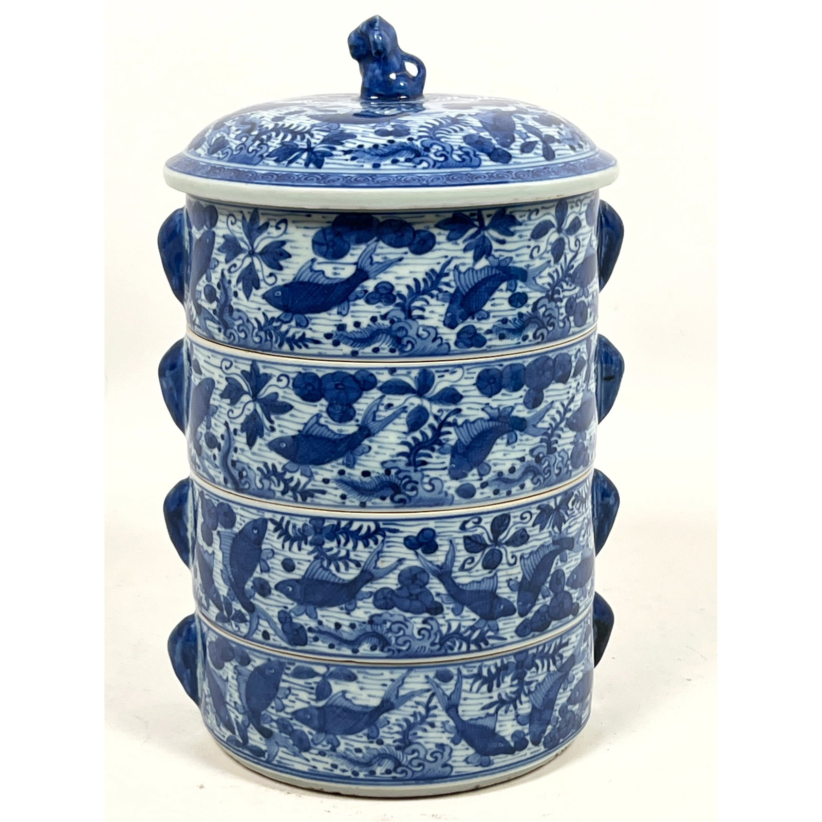 Chinese blue and white four stacked porcelain food containers, also known as a tiffin box or tingkat: Chinese blue and white four stacked porcelain food containers, also known as a tiffin box or tingkat, with a matching domed lid Dimensions: Height: 10.5 inches, Width: 6.5 inches, Depth: 6.5 inches. -