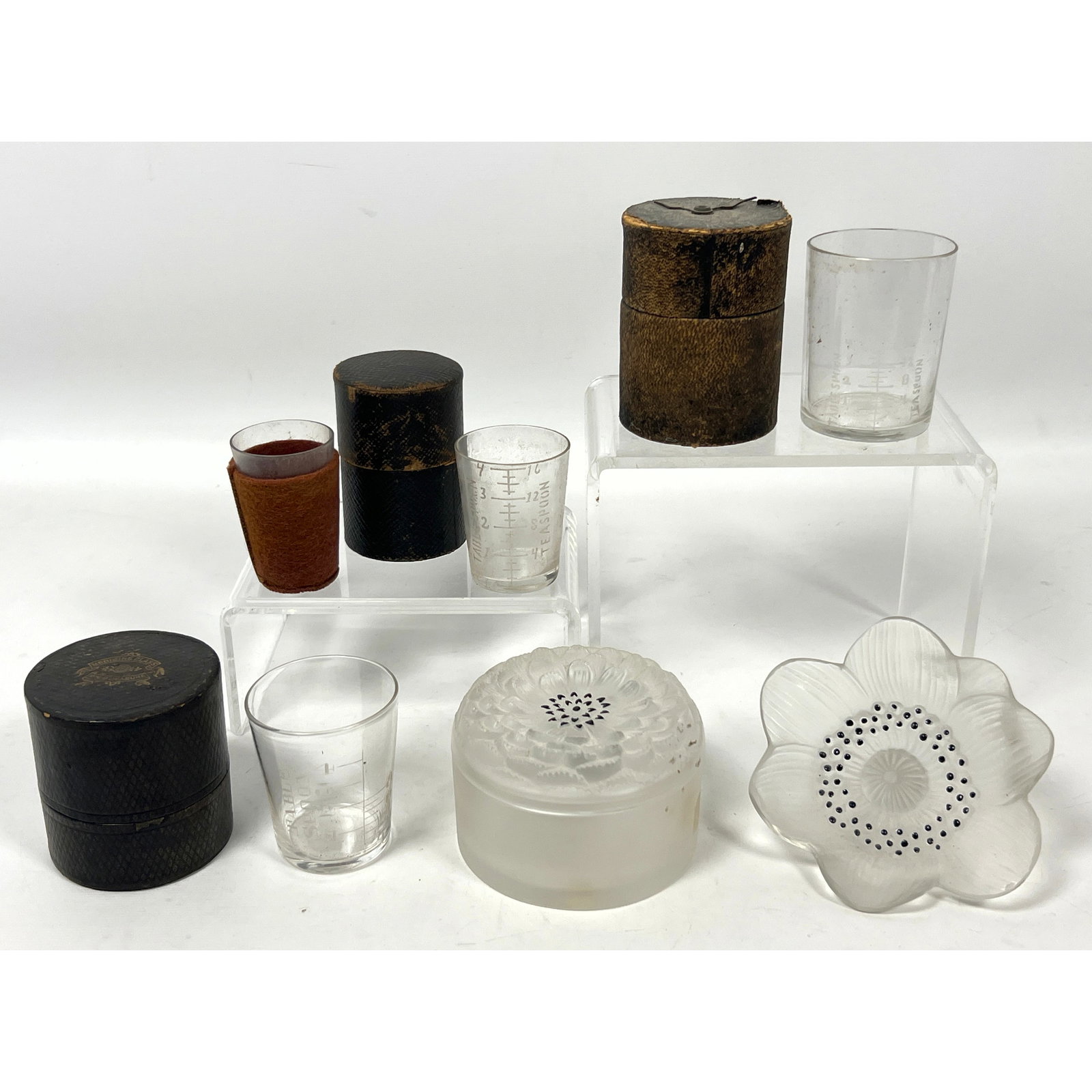 Vintage French art glass and antique apothecary measuring sets. Lalique and Medicine Glass and Minim: Vintage French art glass and antique apothecary measuring sets. Lalique and Medicine Glass and Minim Measure set housed in a black pebbled-texture cylindrical case with gilt lettering Dimensions: Heig