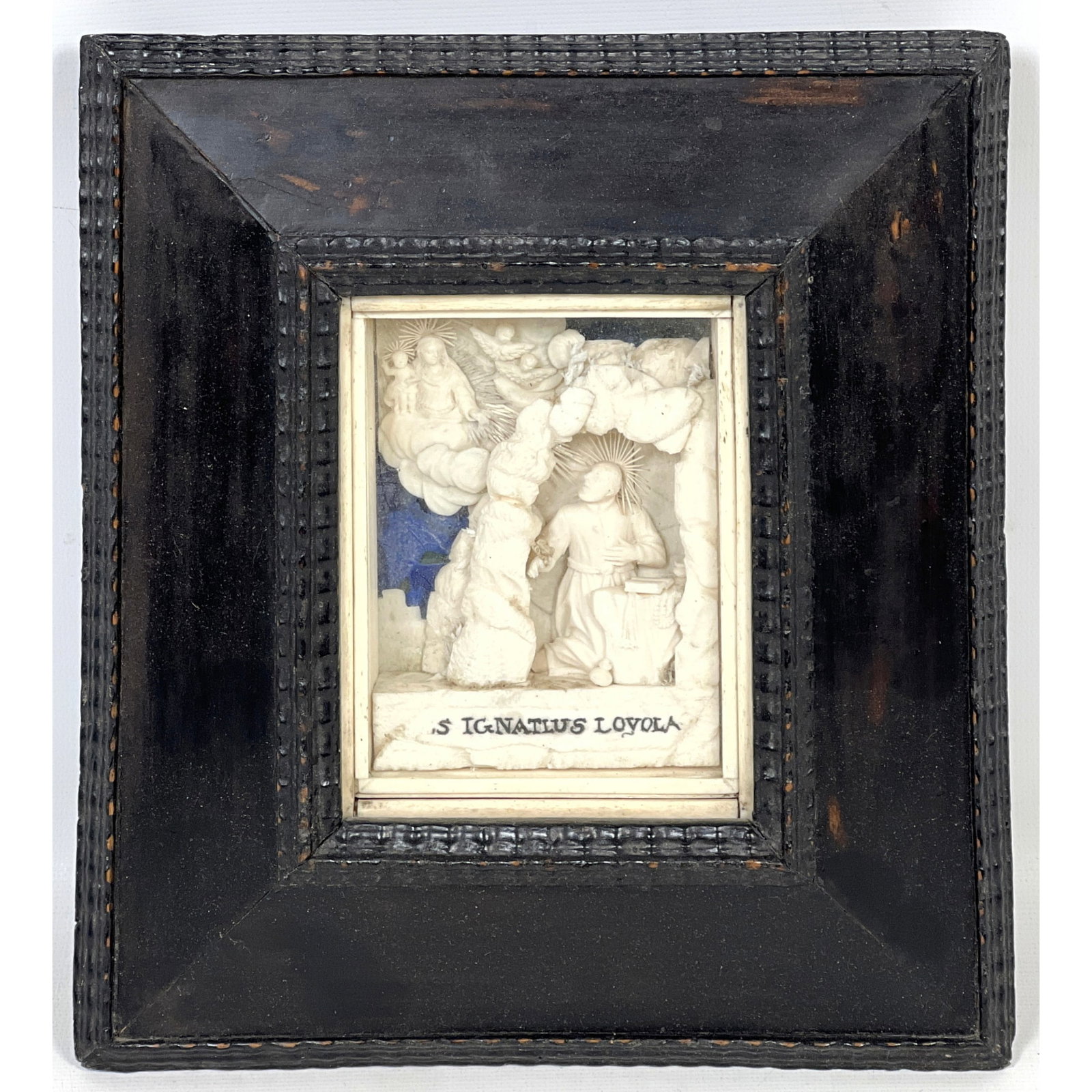 Antique Wax relief sculpture devotional carving Saint Ignatius of Loyola. The saint is shown kneelin: Antique Wax relief sculpture devotional carving Saint Ignatius of Loyola. The saint is shown kneeling in prayer within a rocky grotto, gazing upward toward a celestial manifestation of the Virgin Mary